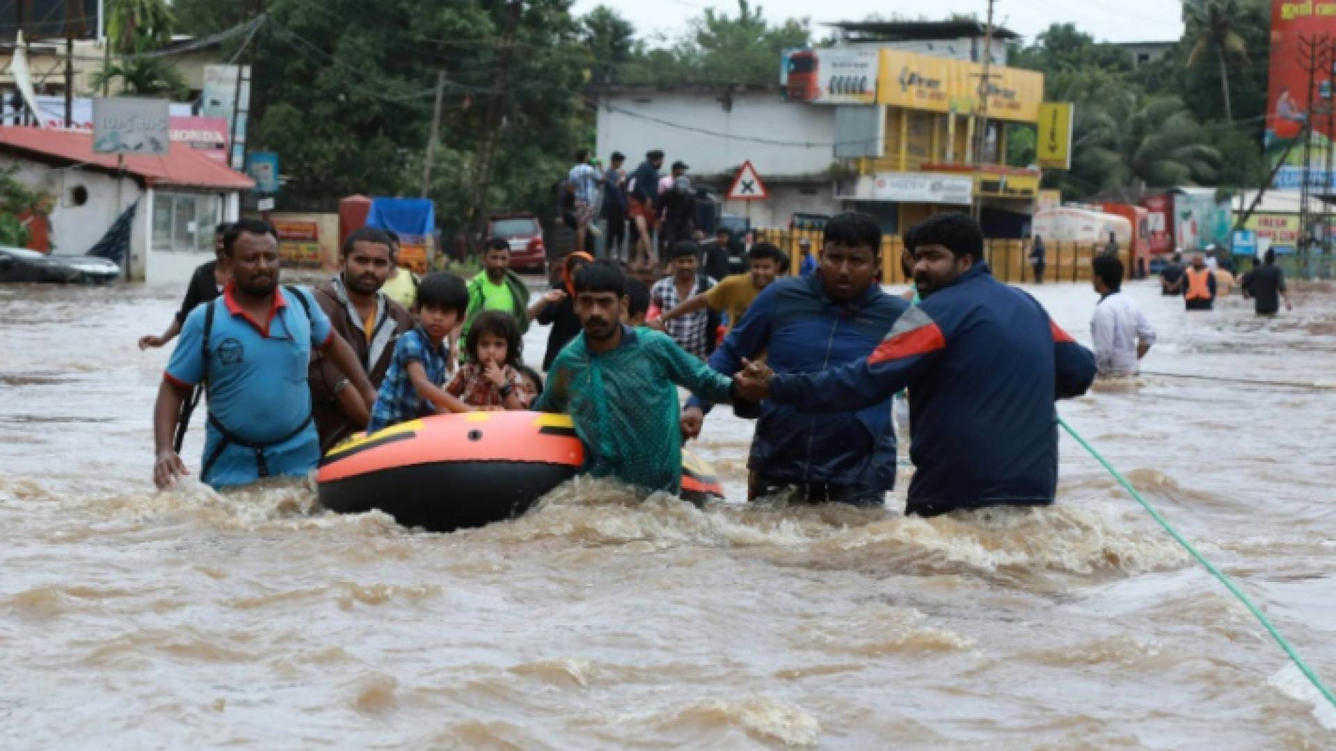 متطوعون وعناصر انقاذ يجلون السكان المحليين بقارب في منطقة سكنية في ولاية كيرالا بالهند