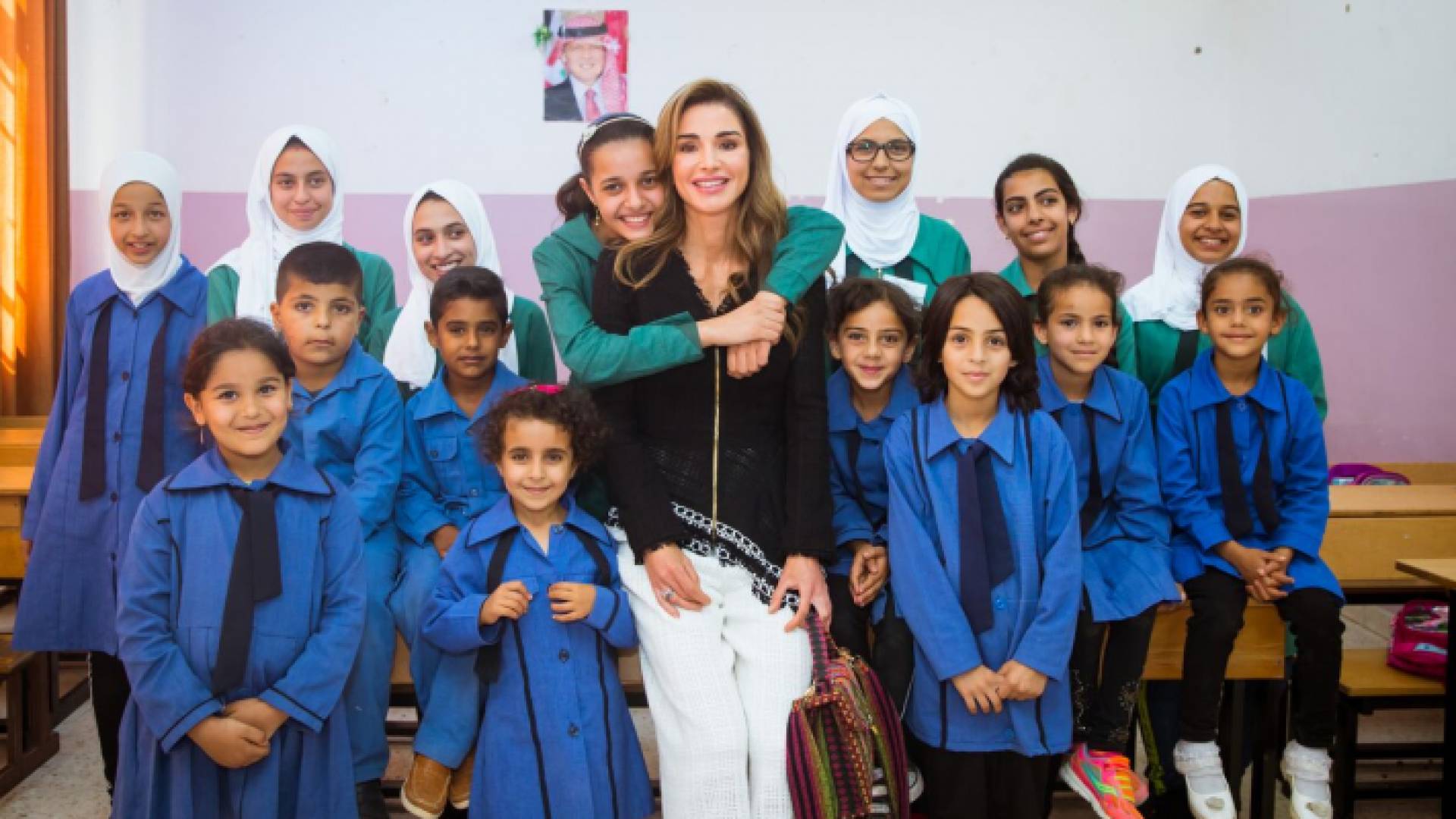 صورة لعدد من الطالبات مع الملكة رانيا