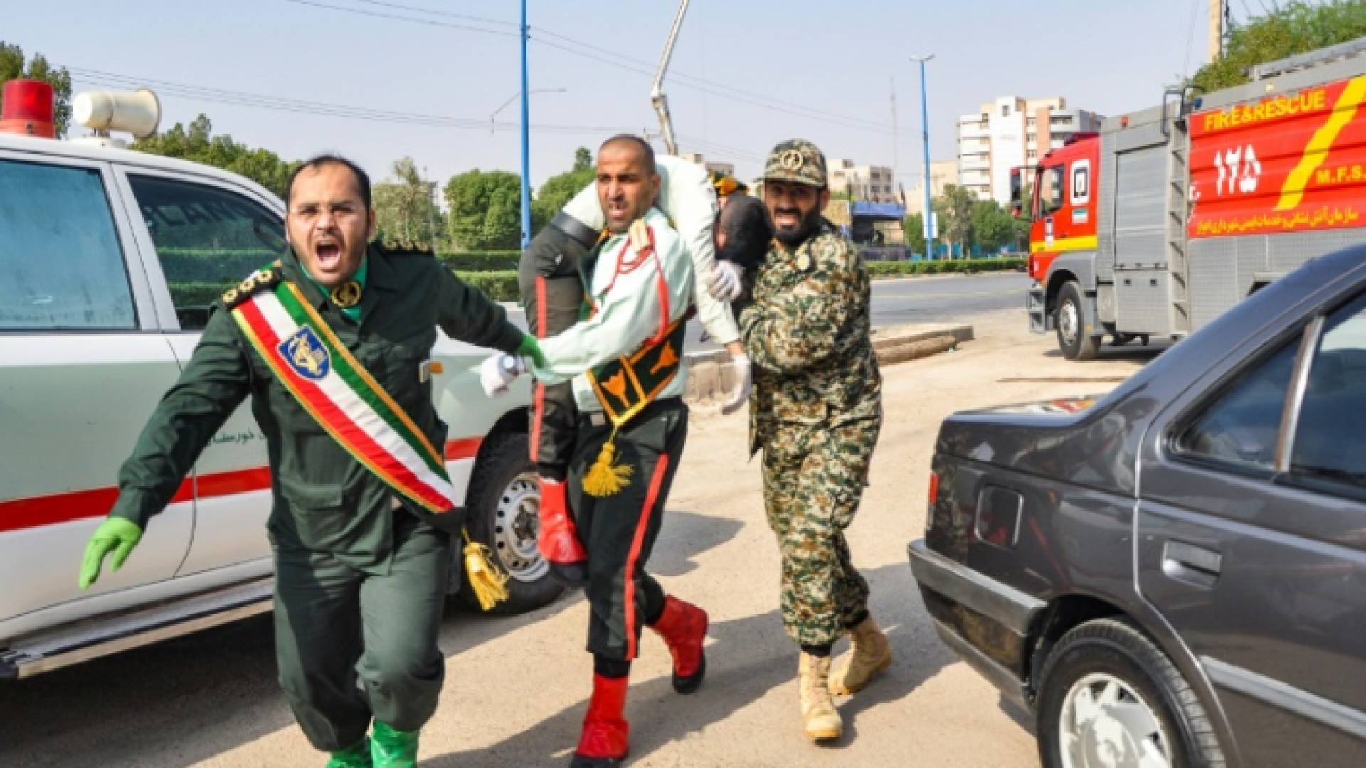 رجل يحمل جنديا إيرانيا أصيب في هجوم الأهواز