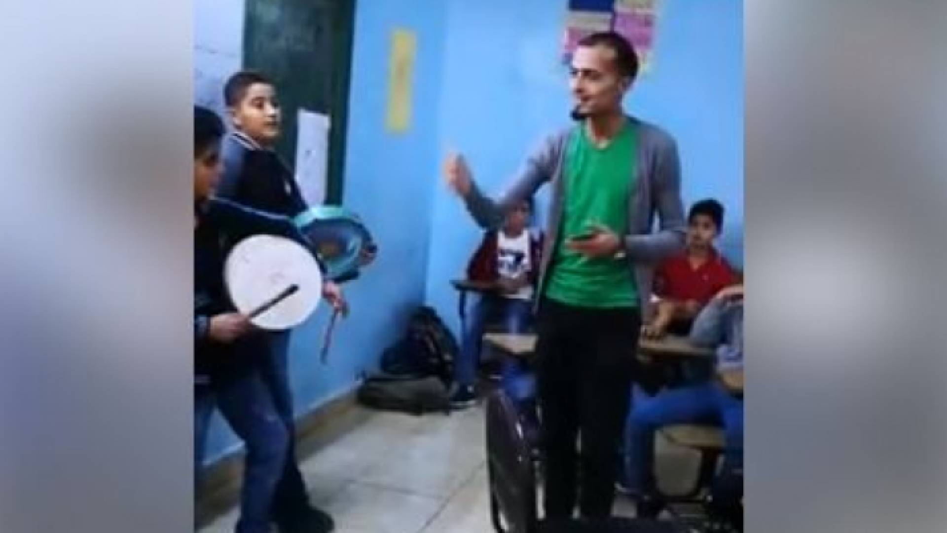 معلم يشارك طلبته الغناء في إحدى مدارس إربد