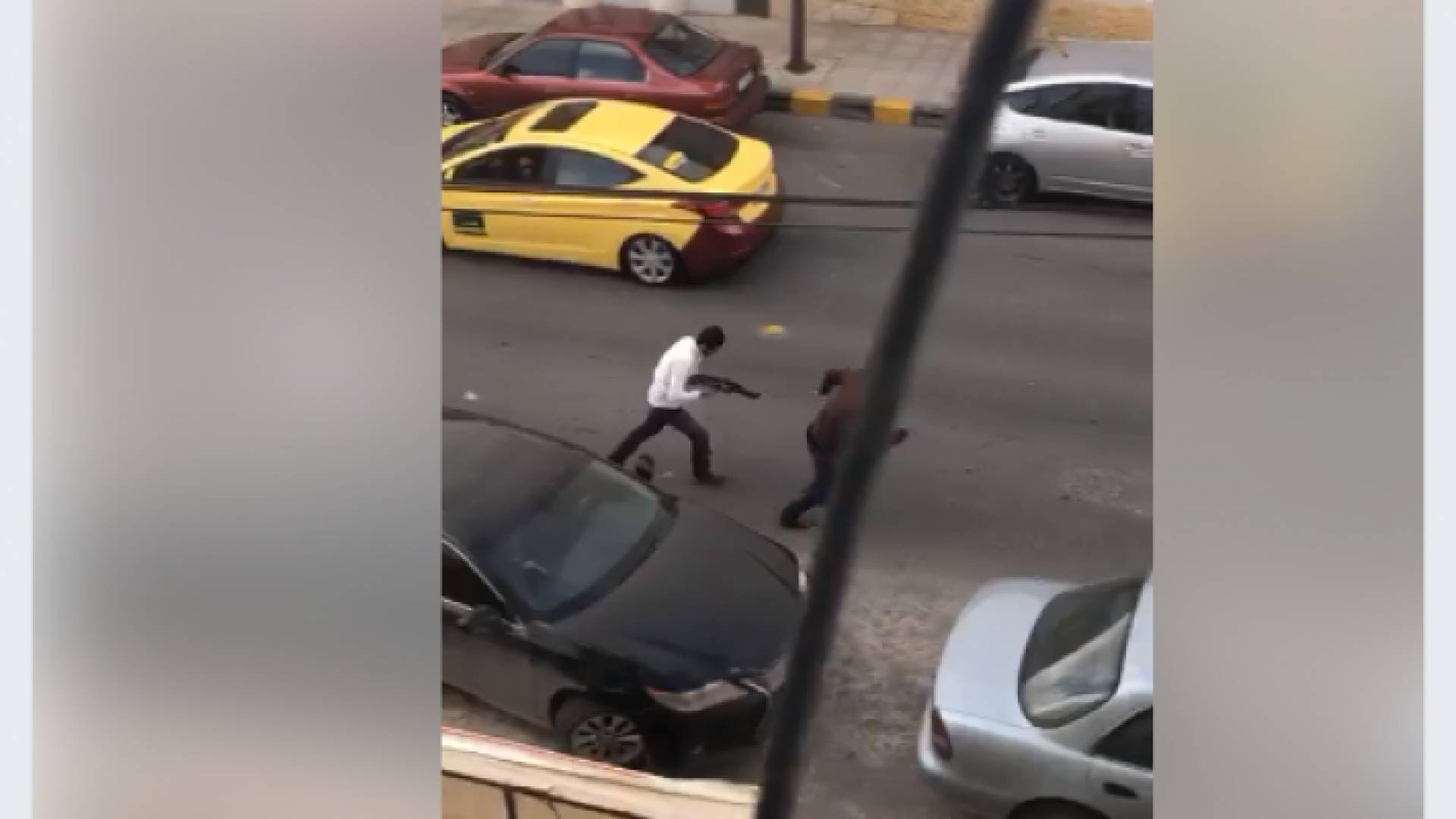 شخص يجري وهو يحمل سلاحا في محيط جامعة البتراء