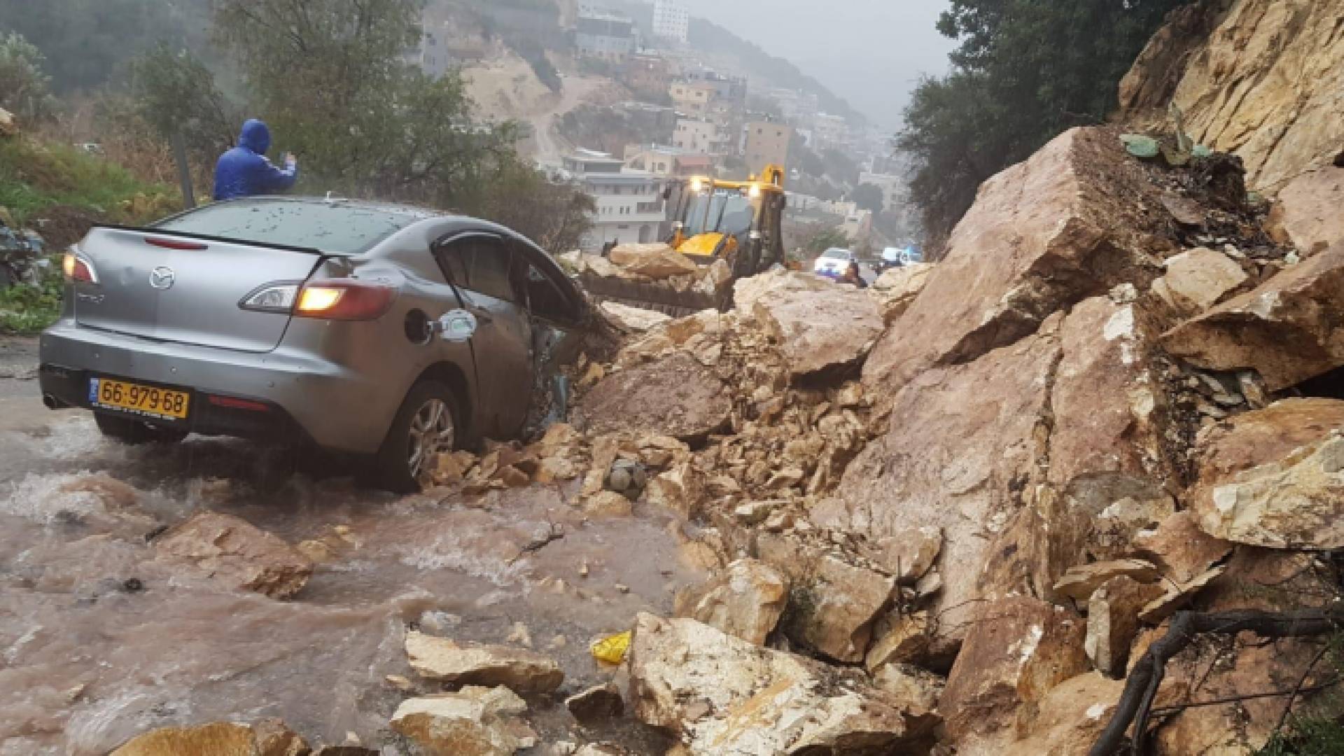 إحدى السيارات التي علقت تحت الانهيار الصخري