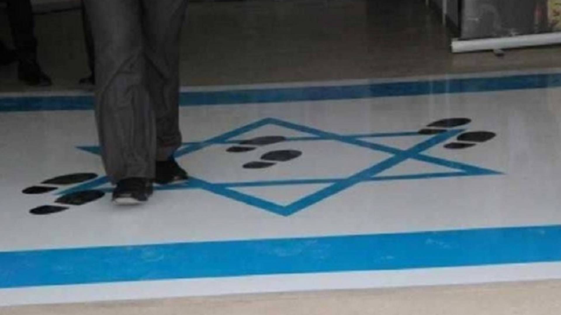 احد الاشخاص يدوس علم الاحتلال على مدخل مجمع النقابات المهنية - ارشيفية