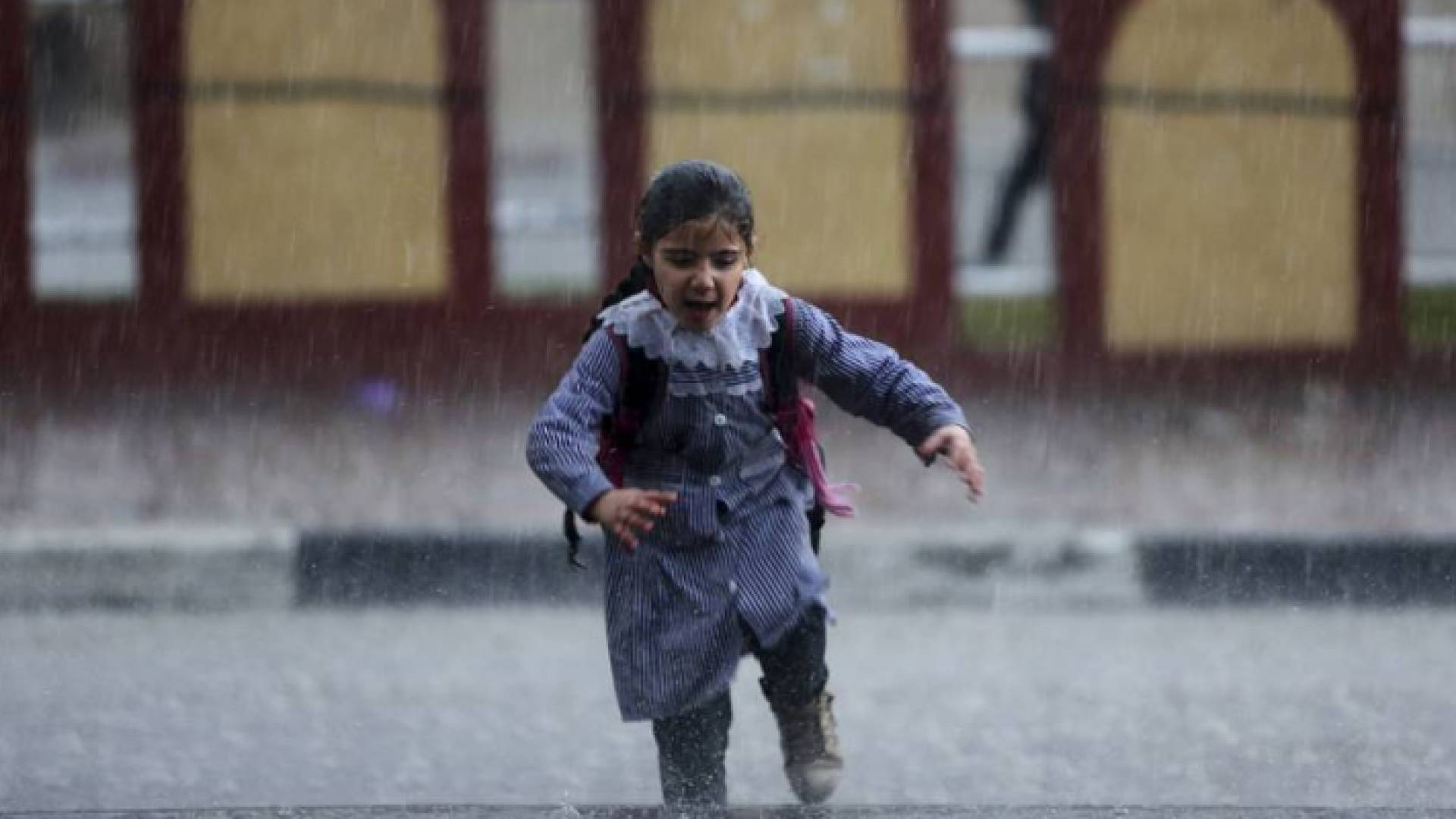 طفلة تحت غزارة الامطار - ارشيفية