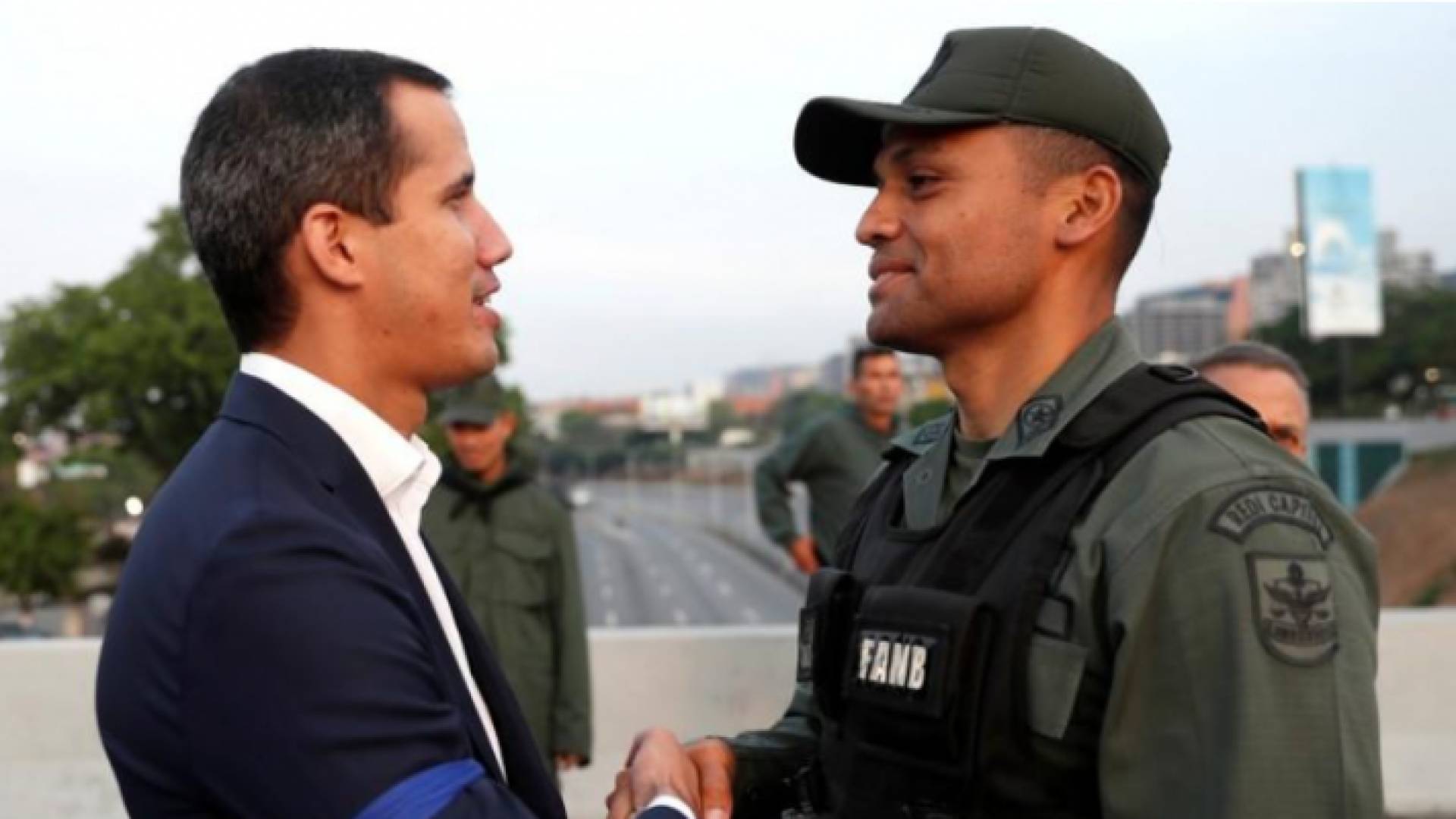 زعيم المعارضة الفنزويلي خوان جوايدو يصافح أحد أفراد الجيش قرب قاعدة جوية في كراكاس الثلاثاء