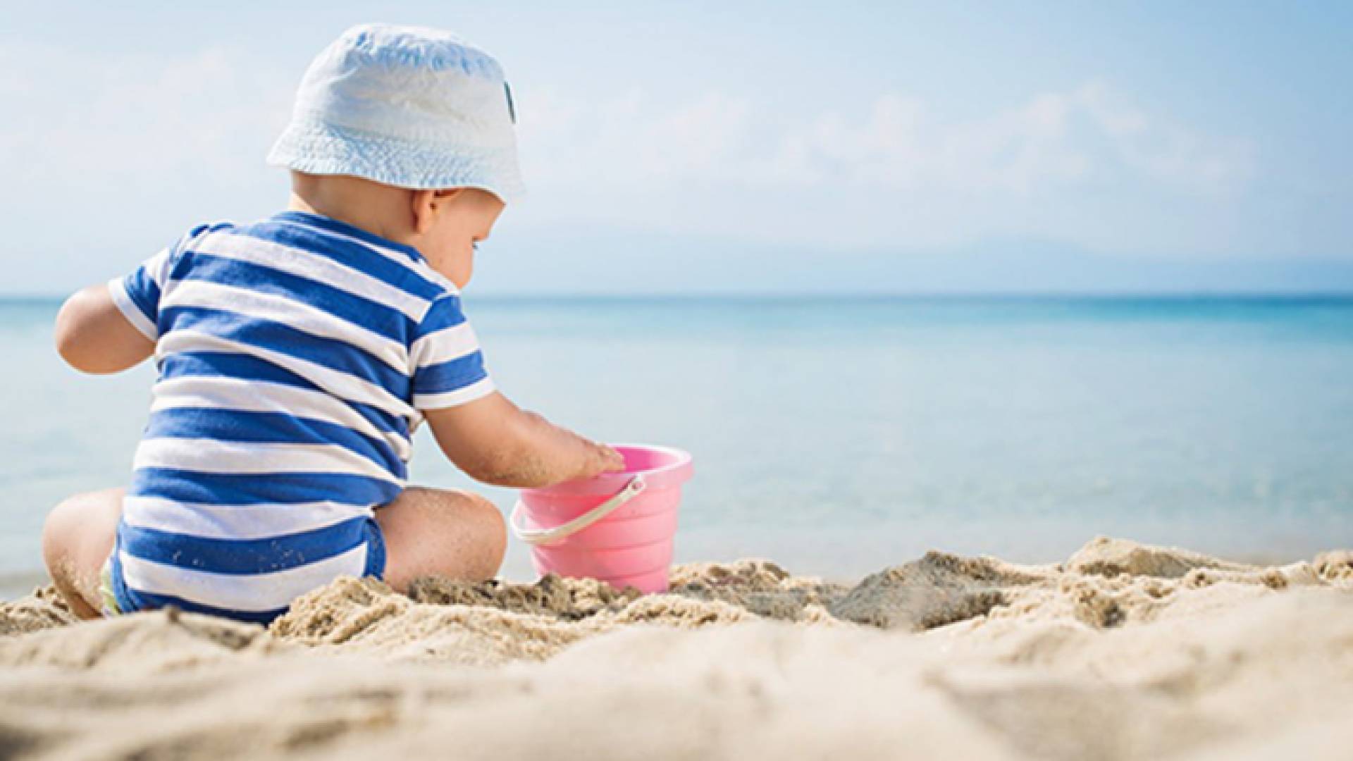 طفل على الشاطئ تحت أشعة الشمس - الصورة تعبيرية