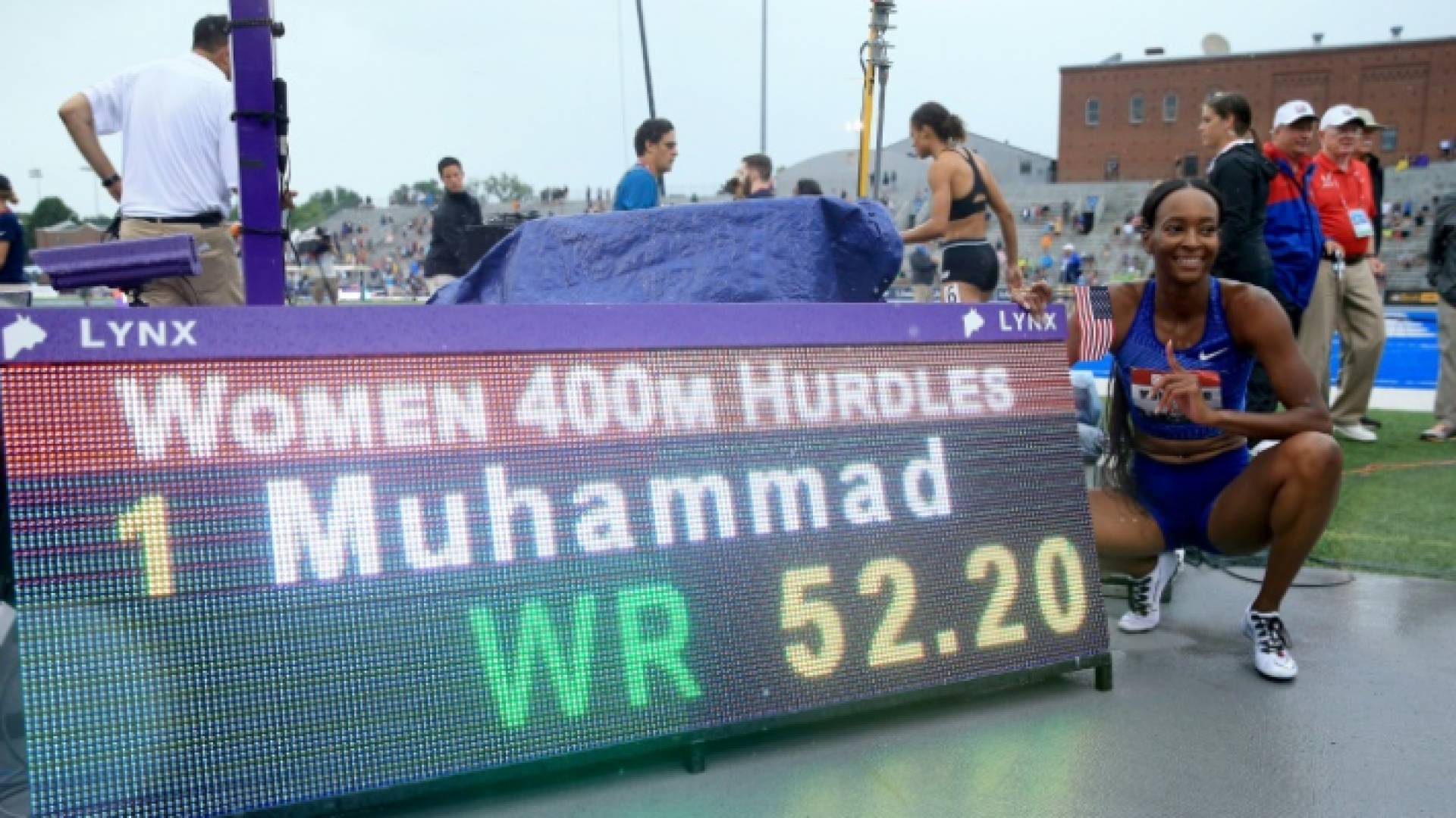 العداءة الامريكية دليلة محمد تلتقط صورة إلى جانب اللوحة الالكترونية التي تشير إلى رقمها القياسي العالمي في سباق 400 م حواجز والذي سجلته في بطولة الولا