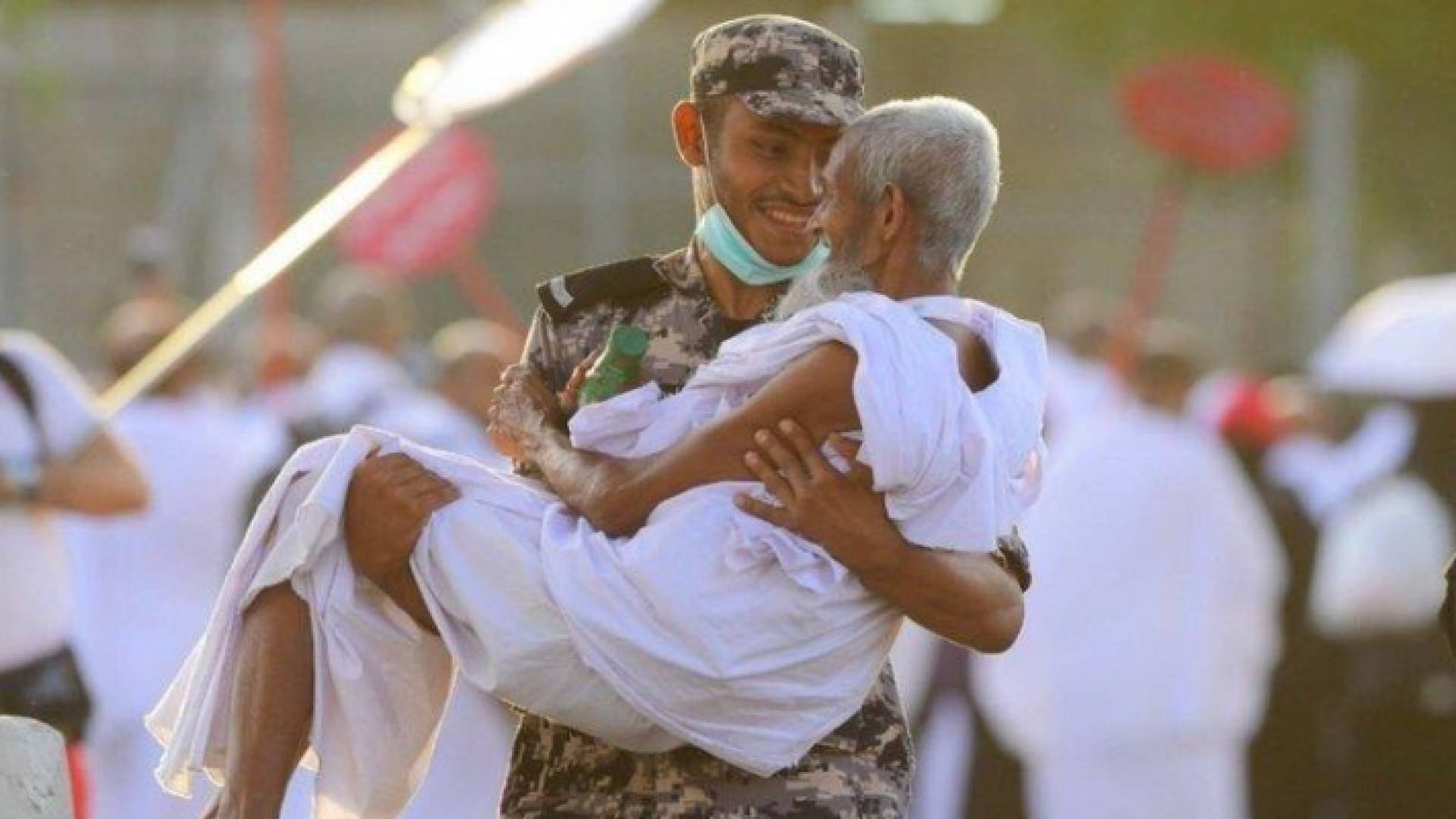 رجل الامن يحمل حاجا مسنا