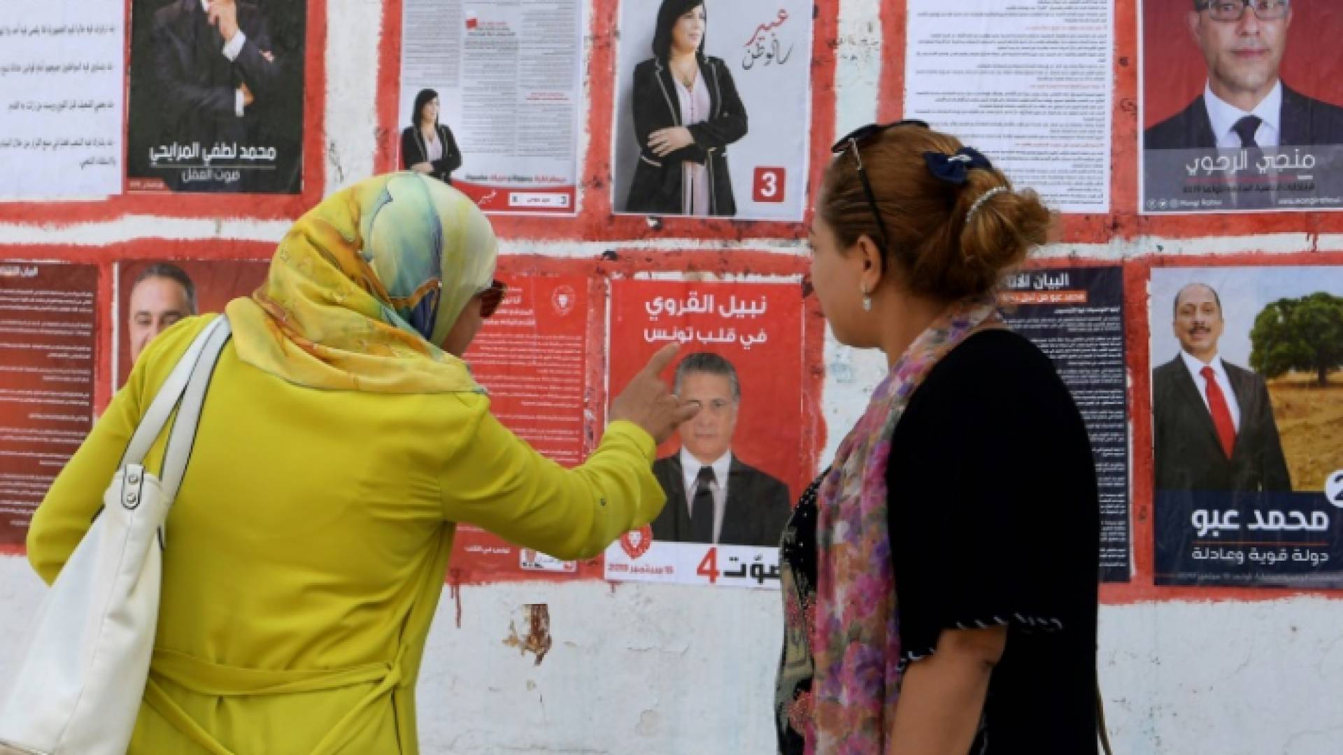 تونسيتان تنظران الى لافتات انتخابية