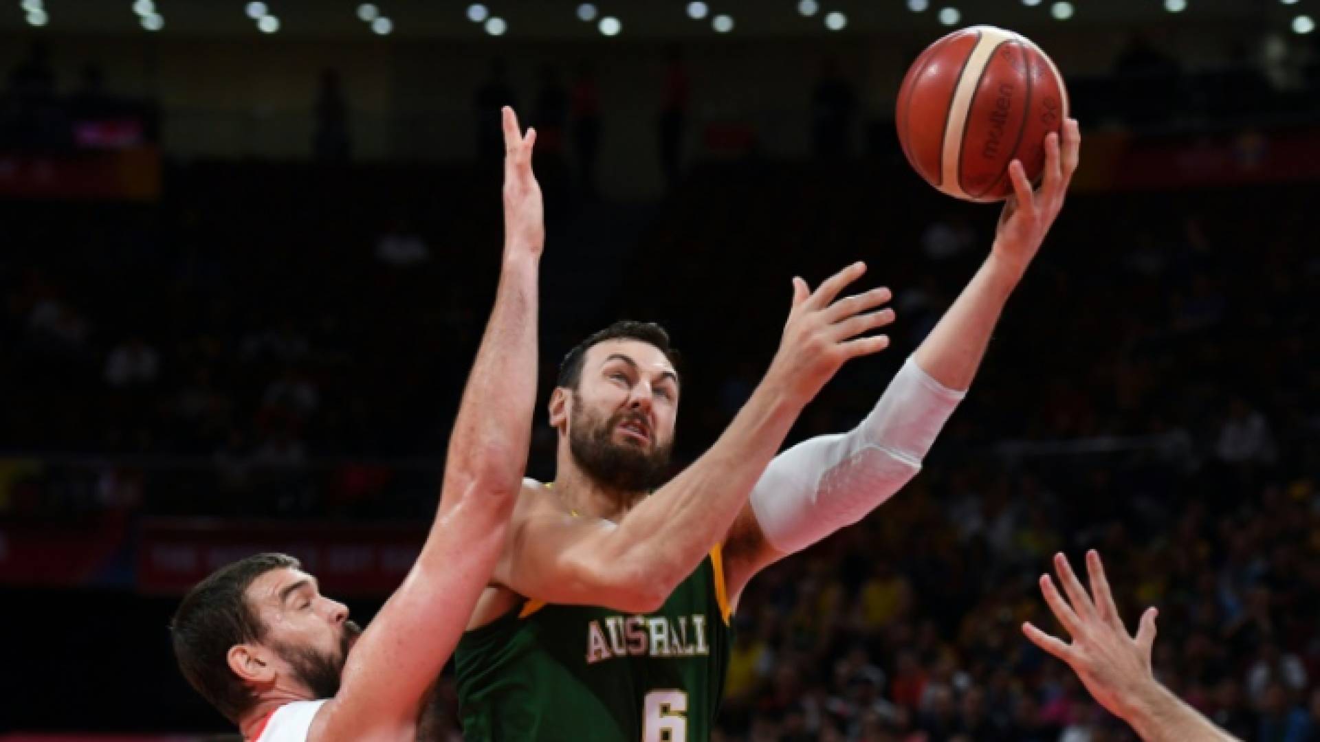 الأسترالي أندرو بوغوت يتقدم بالكرة نحو سلة المنتخب الإسباني