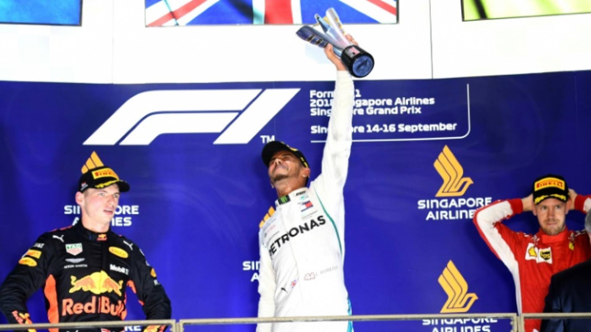 البريطاني لويس هاميلتون (وسط) يحتفل بفوزه بجائزة سنغافورة الكبرى في بطولة العالم للفورولا