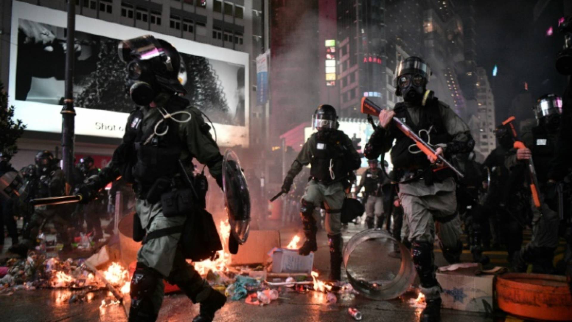 الشرطة تعبر قرب بقايا أشعلها متظاهرون في منطقة كوزواي باي في هونغ كونغ