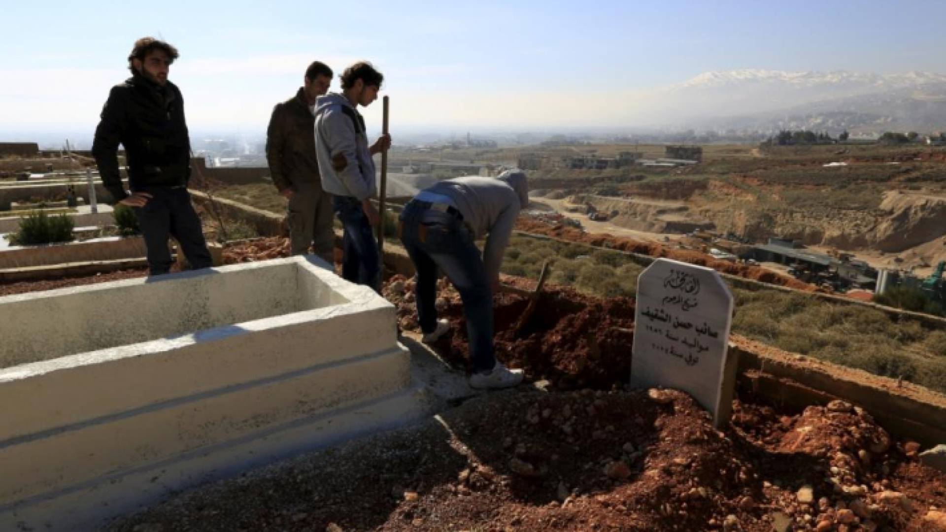 لاجئون سوريون يدفنون أحد موتاهم في سهل البقاع اللبناني