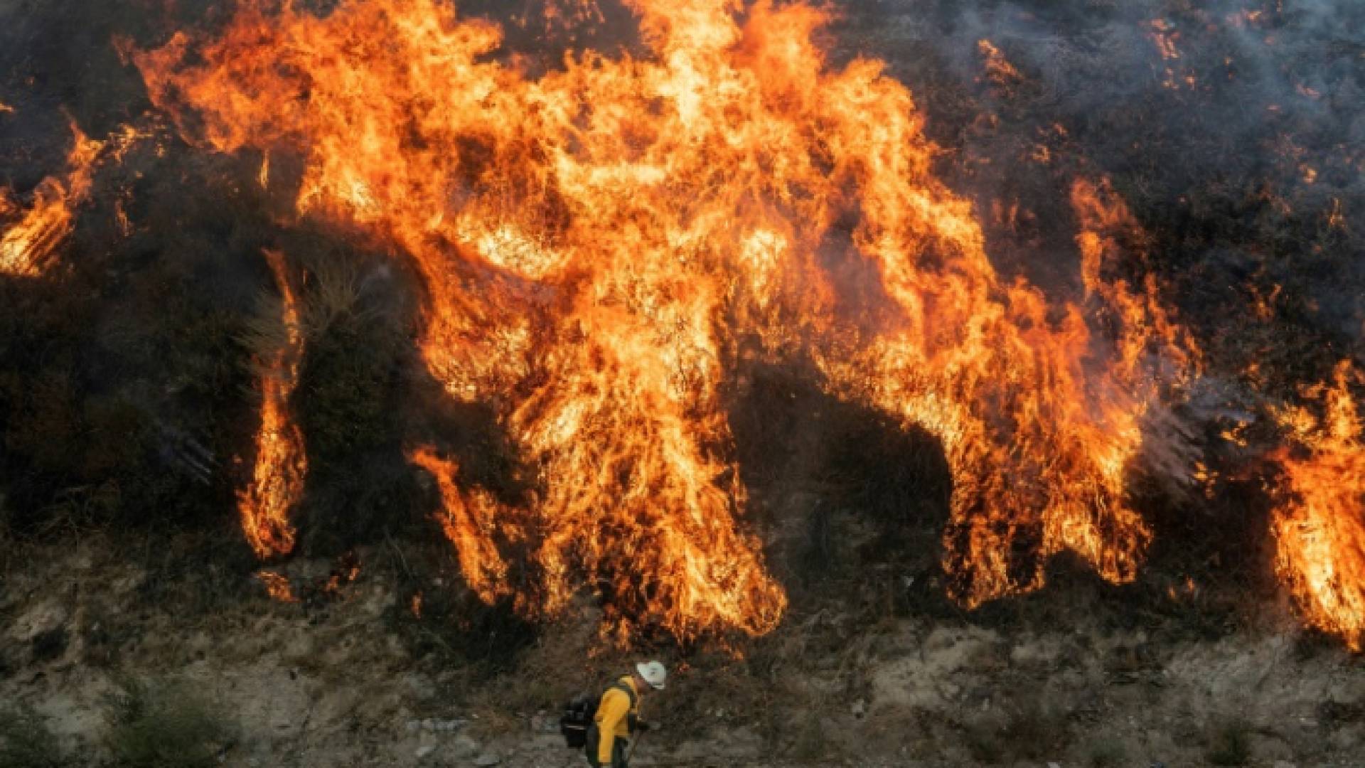 رجل إطفاء يسير قرب حريق في نيوهول في كاليفورنيا