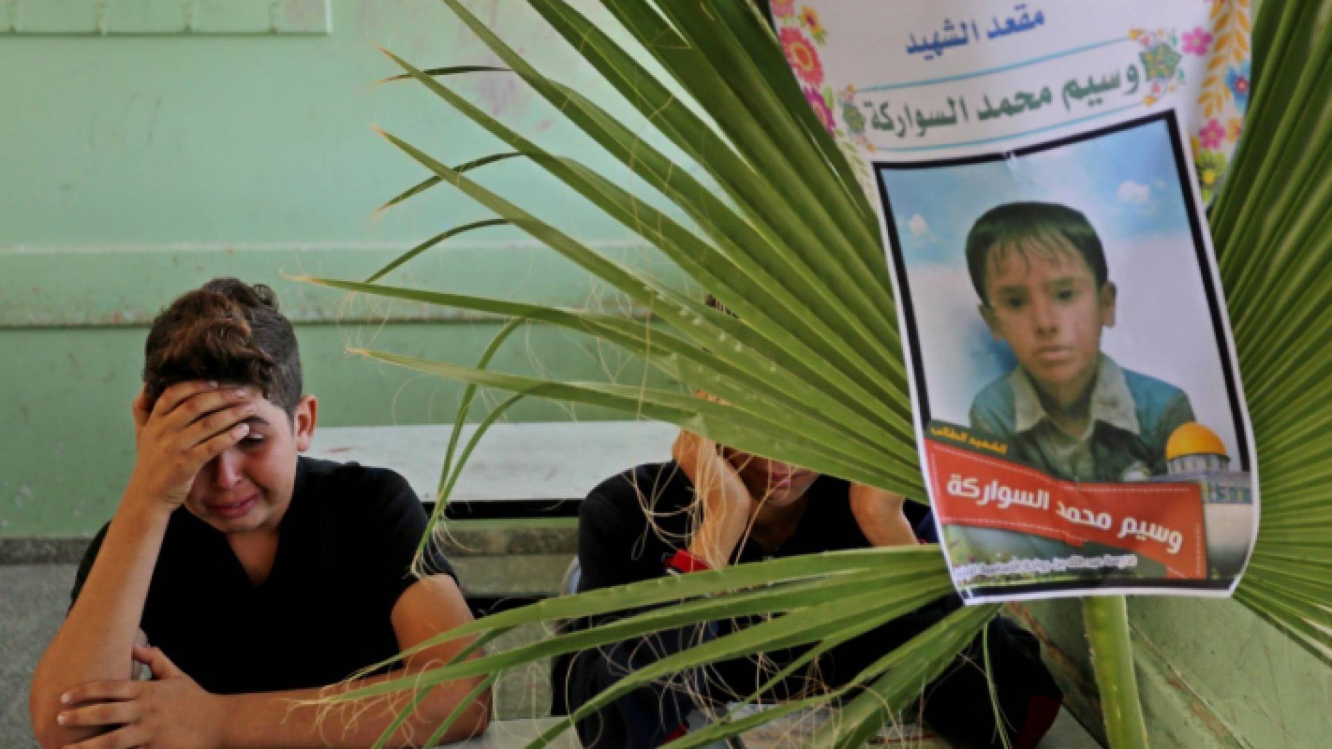 طفل فلسطيني يبكي زميله بالمدرسة الذي قضى بقصف الاحتلال عائلة السواركة