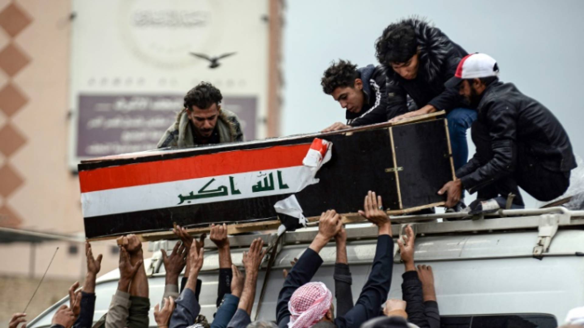 عراقيون يحملون نعش أحد قتلى التظاهرات في النجف