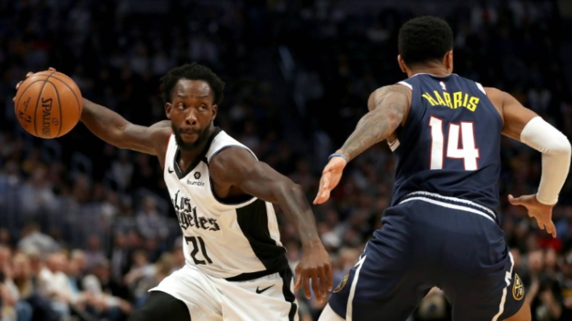 لاعب لوس انجليس كليبرز باتريك بيفيرلي يحاول تخطي منافسه غاري هاريس من دنفر ناغتس ضمن دوري كرة السلة الامريكي