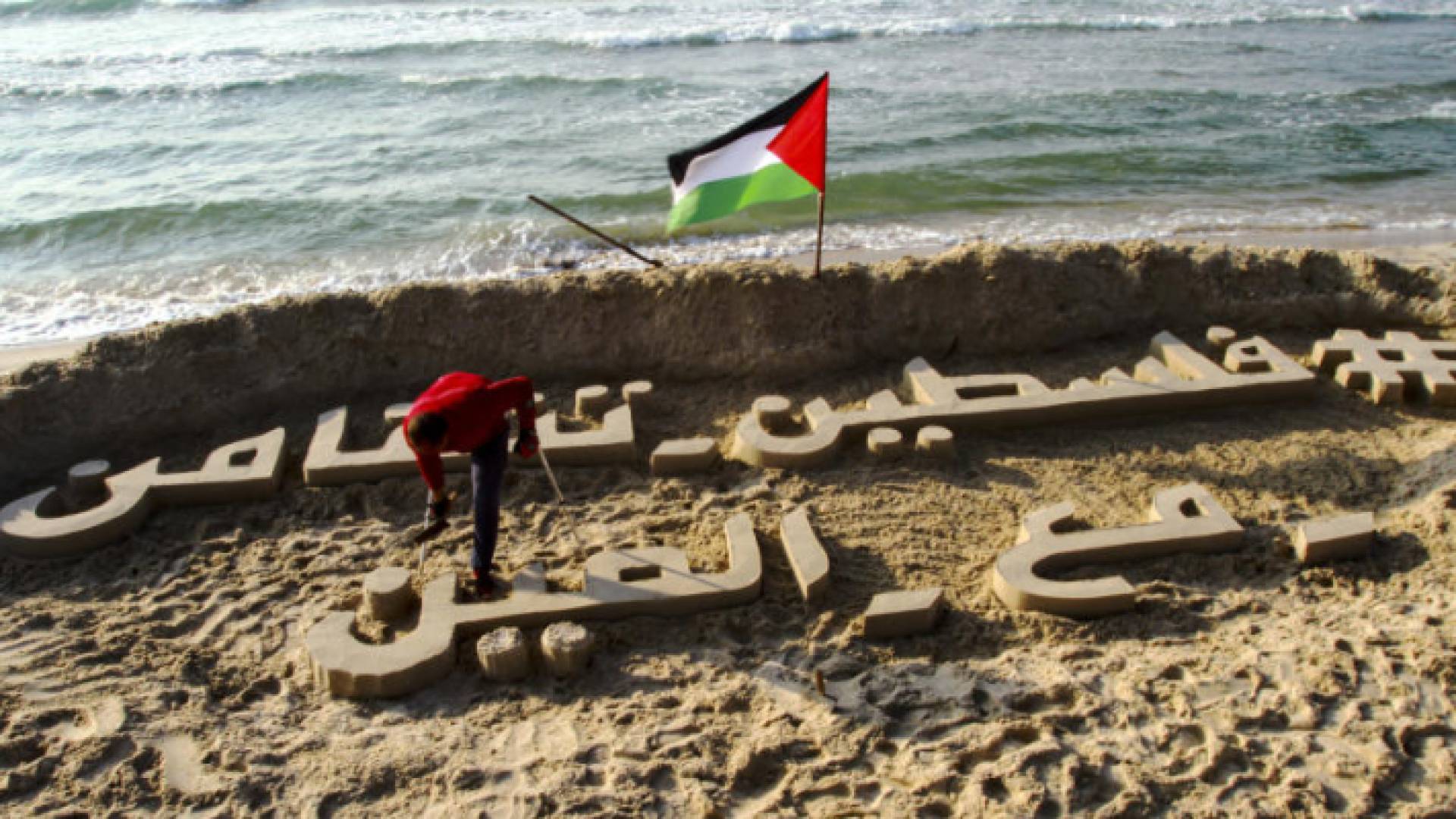 فلسطيني يتضامن مع الصين عبر النحت على رمال بحر غزة