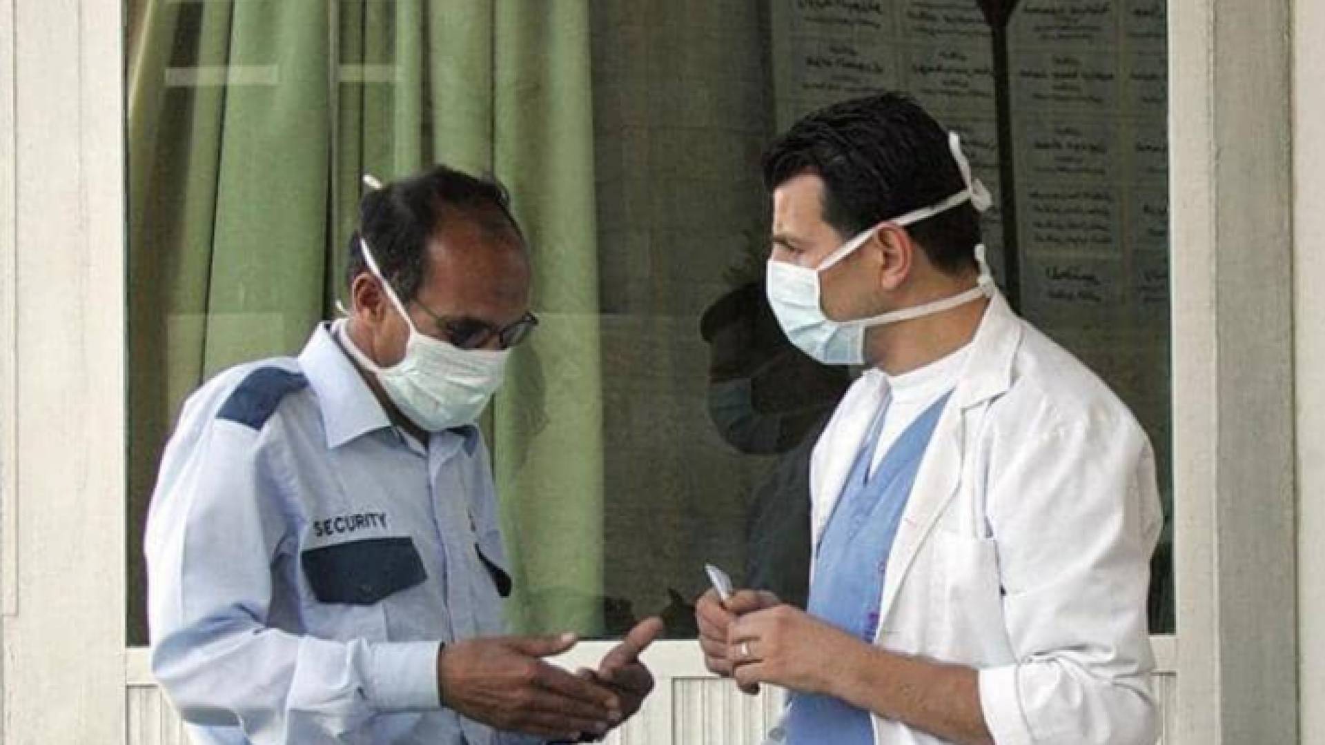 طبيب أردني وموظف يرتديان كمامات في إحدى المستشفيات