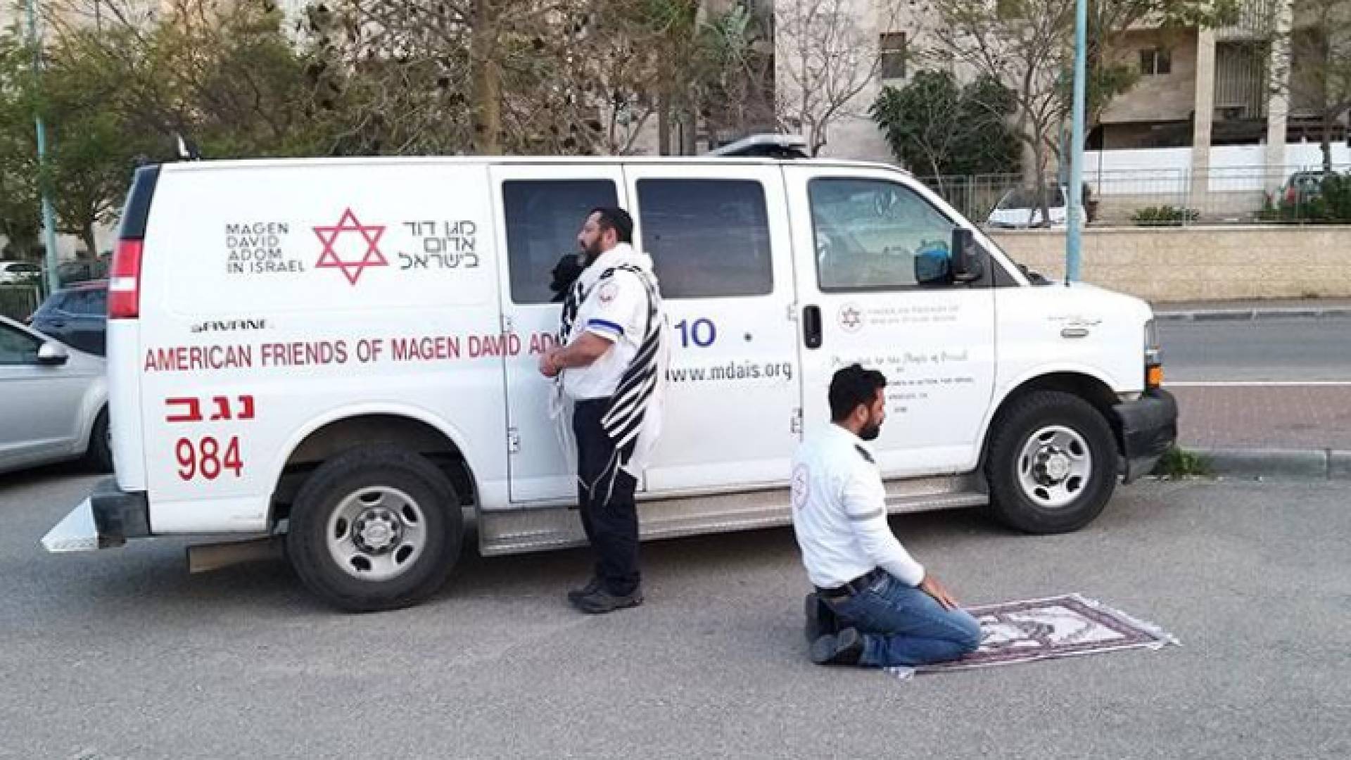 ممرضين يصليان أمام سيارة إسعاف أحدهما يهودي والآخر مسلم