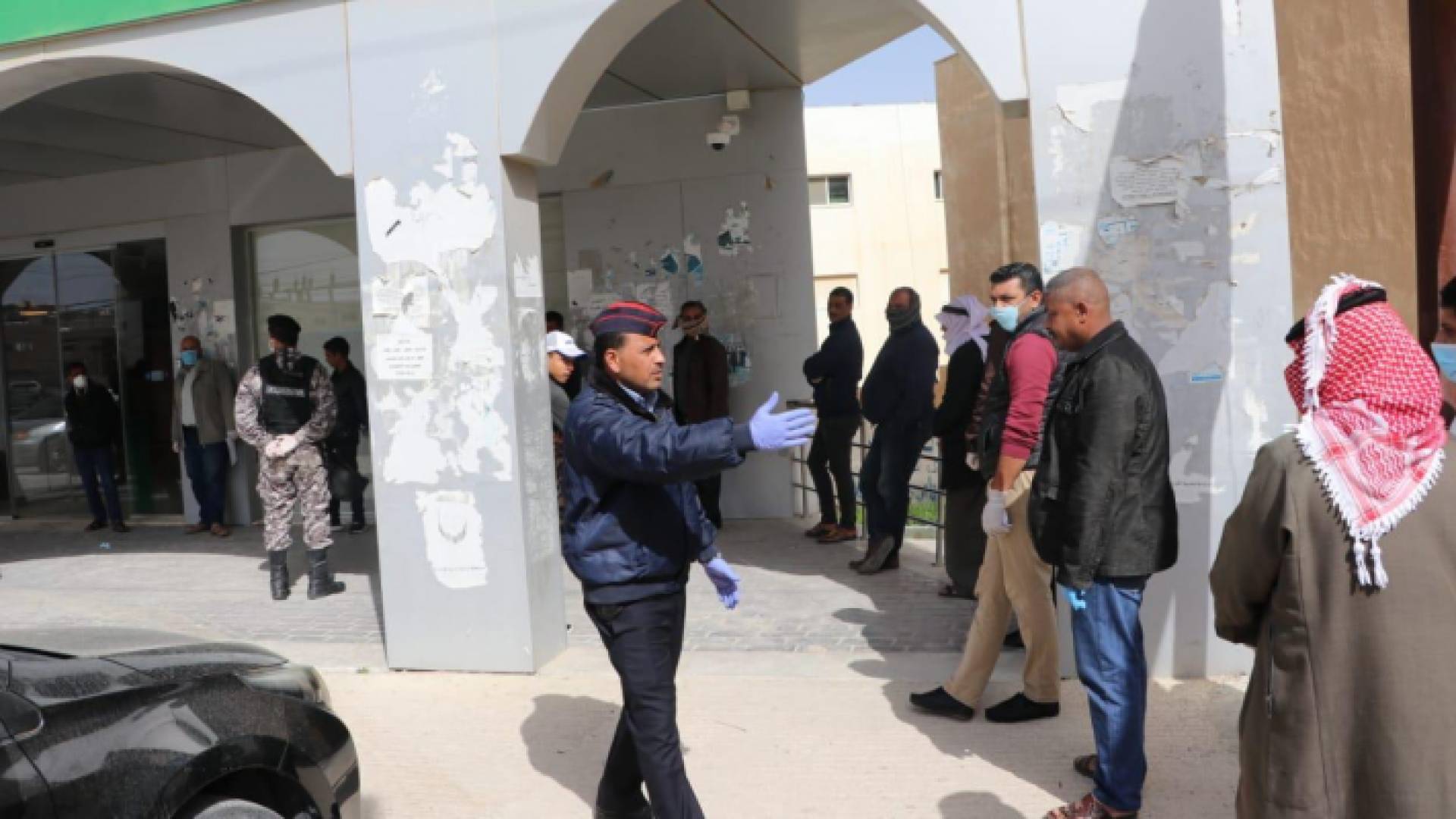 رجال الامن العام ينظمون الاصطفاف والدور أمام فروع البنوك