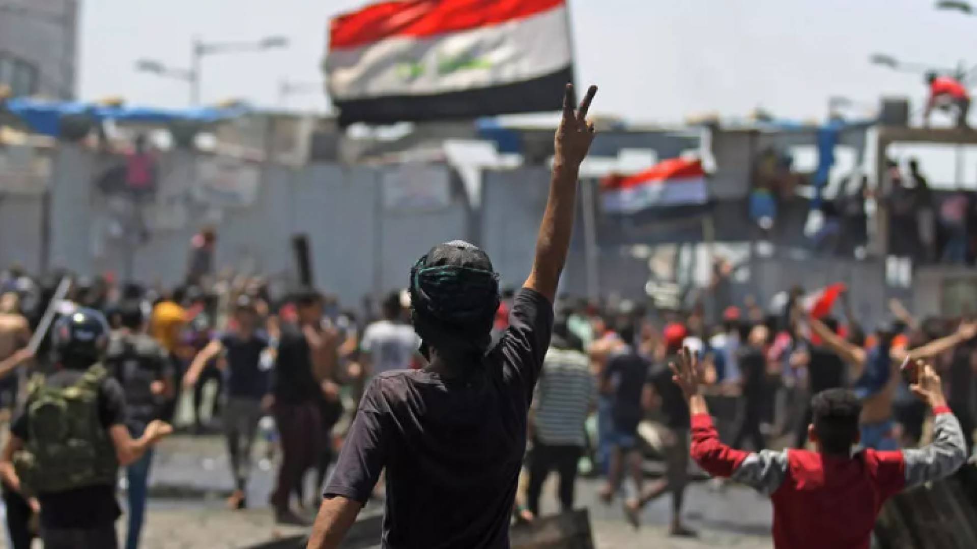 متظاهر عراقي يرفع شارة النصر خلال التظاهرات ضد الحكومة في بغداد
