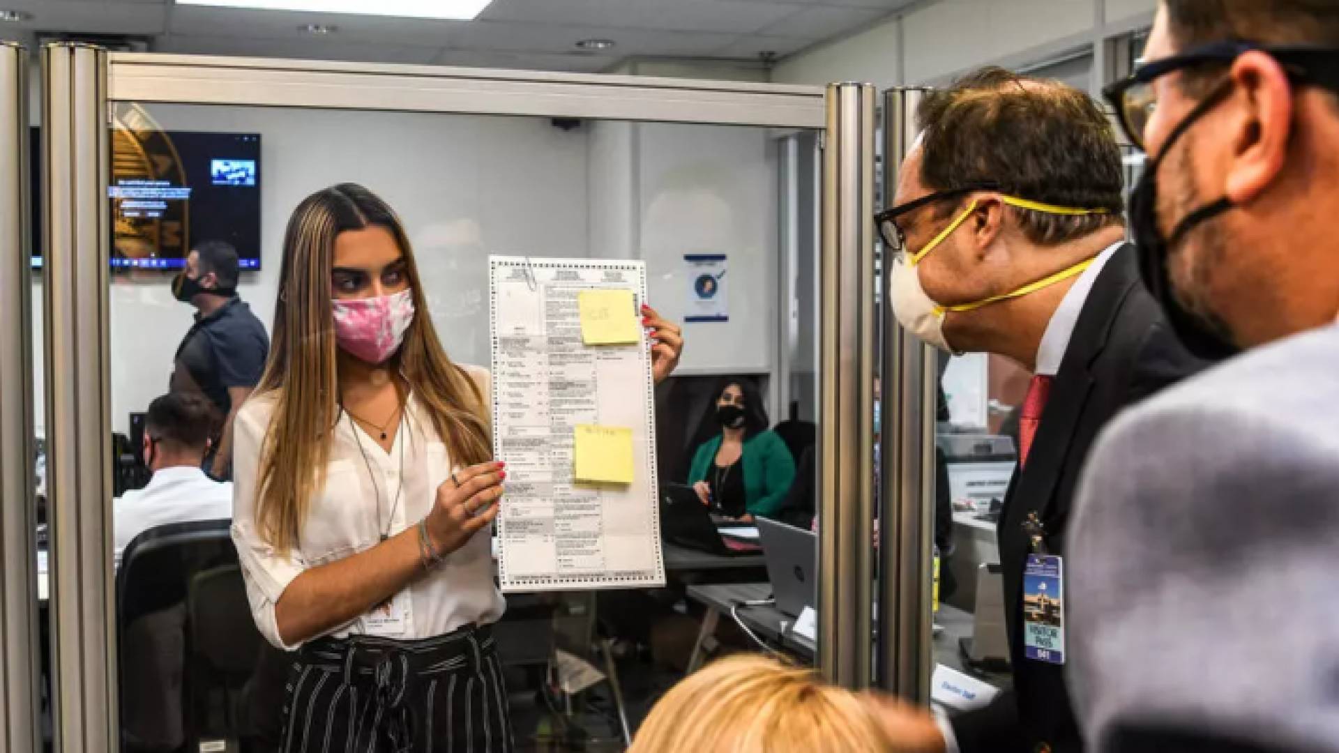 موظفون يدققون في احد الاصوات الذي وصل بالبريد في ميامي