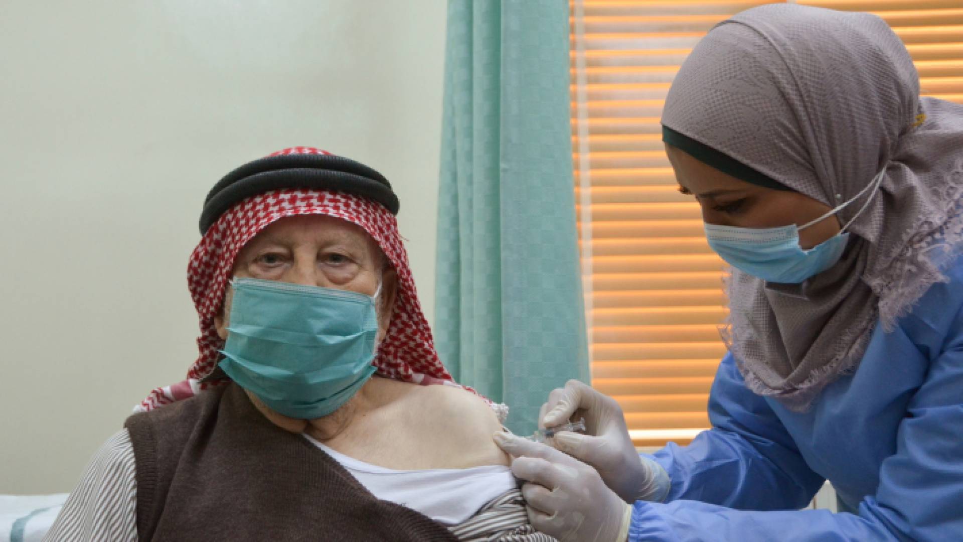 مسن أردني يتلقى لقاحا ضد كورونا عند انطلاق حملة التطعيم في المملكة