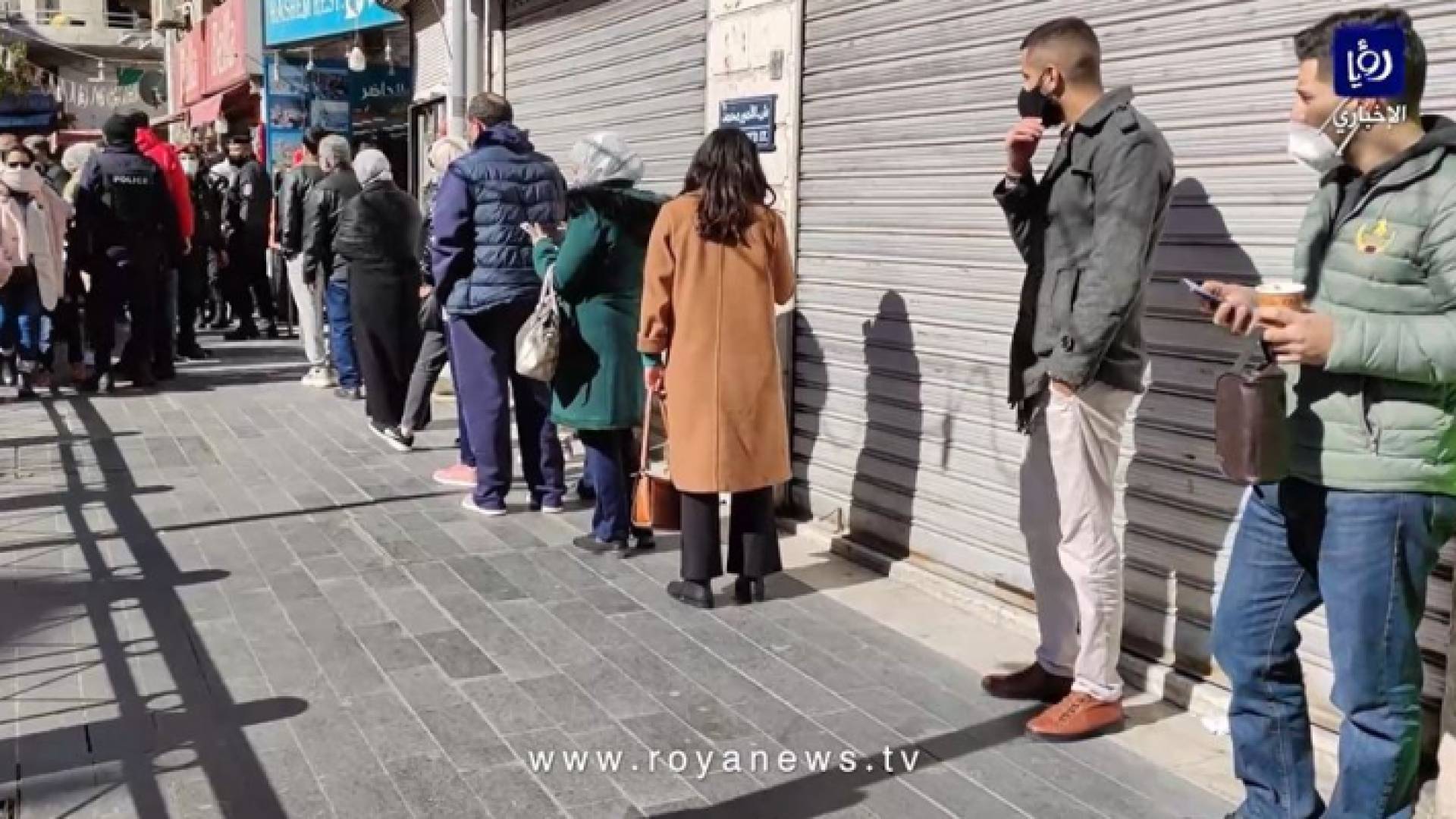 إلتزام عدد من المواطنين بإجراءات الوقاية من كورونا أمام أحد مطاعم وسط البلد