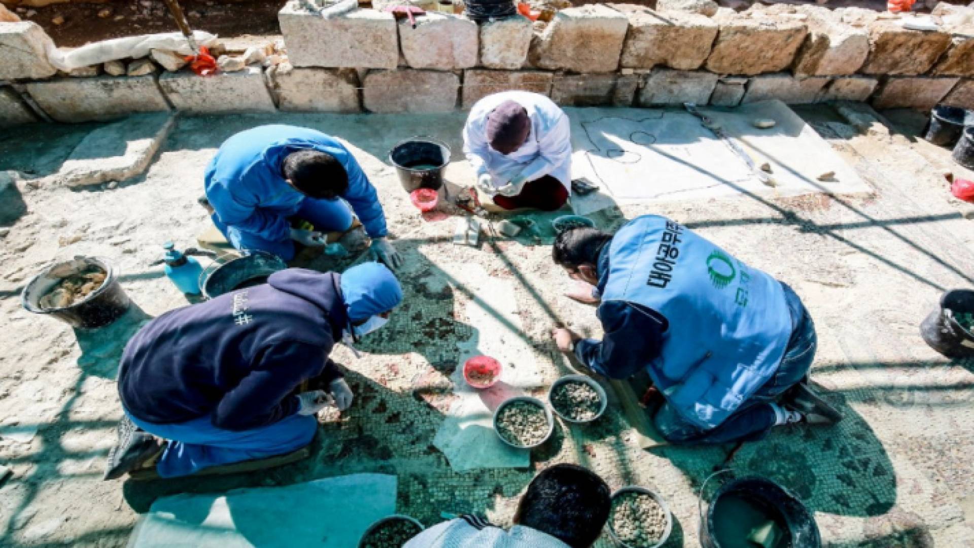 عمال يرممون أرضية فسيفساء في رحاب