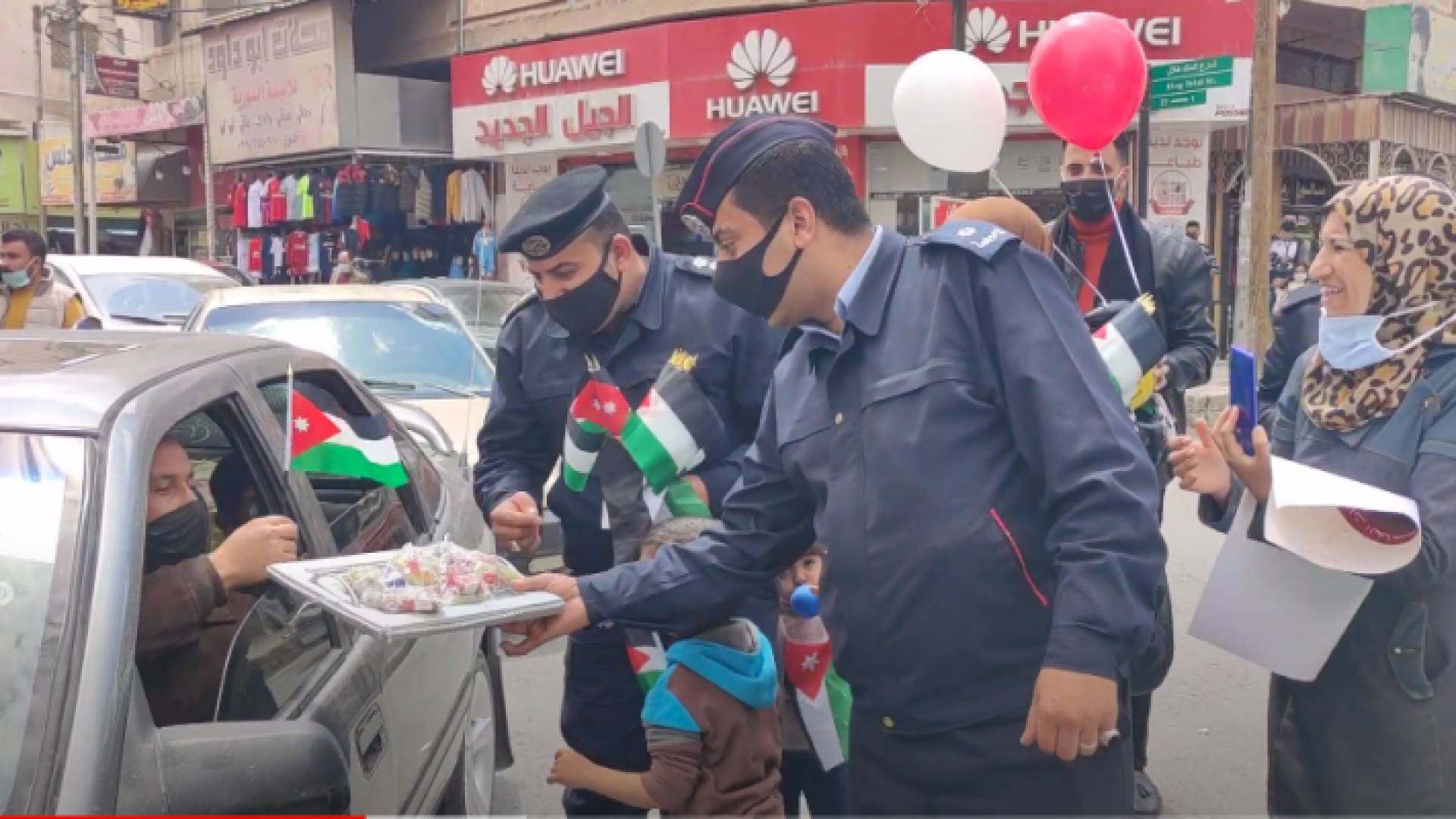شرطيان يوزعان الأعلام والحلوى على مواطني المفرق