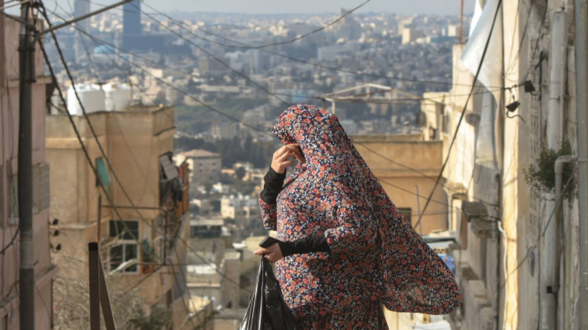 امرأة أردنية تسير بإحدى مناطق العاصمة عمان