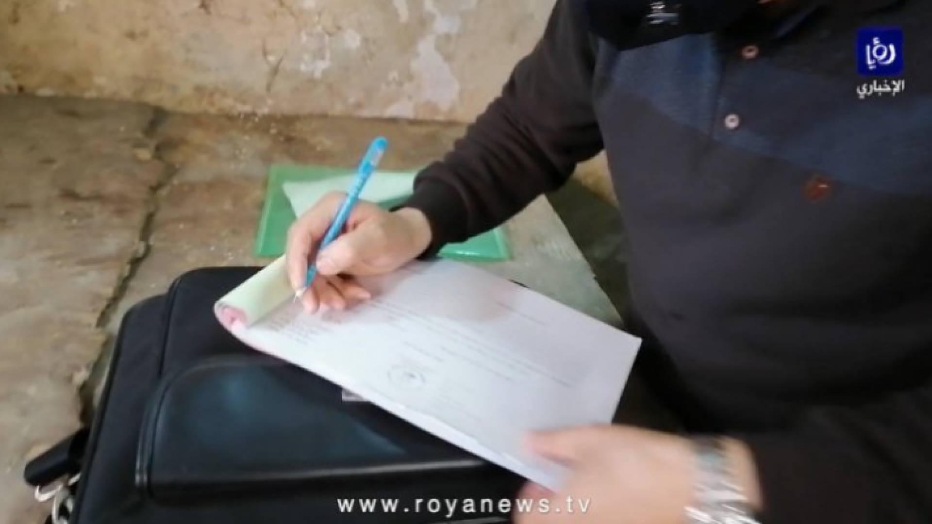 رجل أمن يقوم بكتابة مخالفة لإحدى المنشآت التجارية - أرشيفية