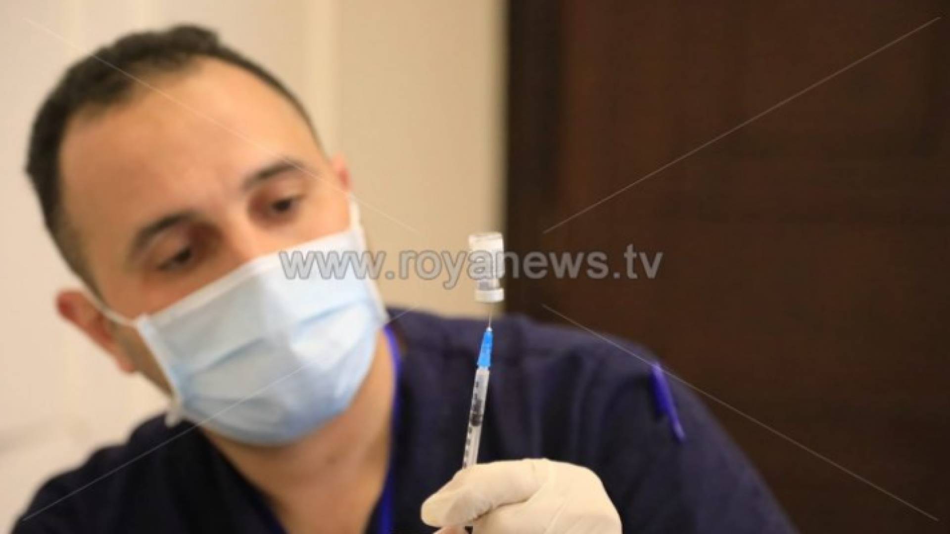 ممرض يجهز حقنة من لقاح كورونا تمهيدا لتطعيم أحد المواطنين