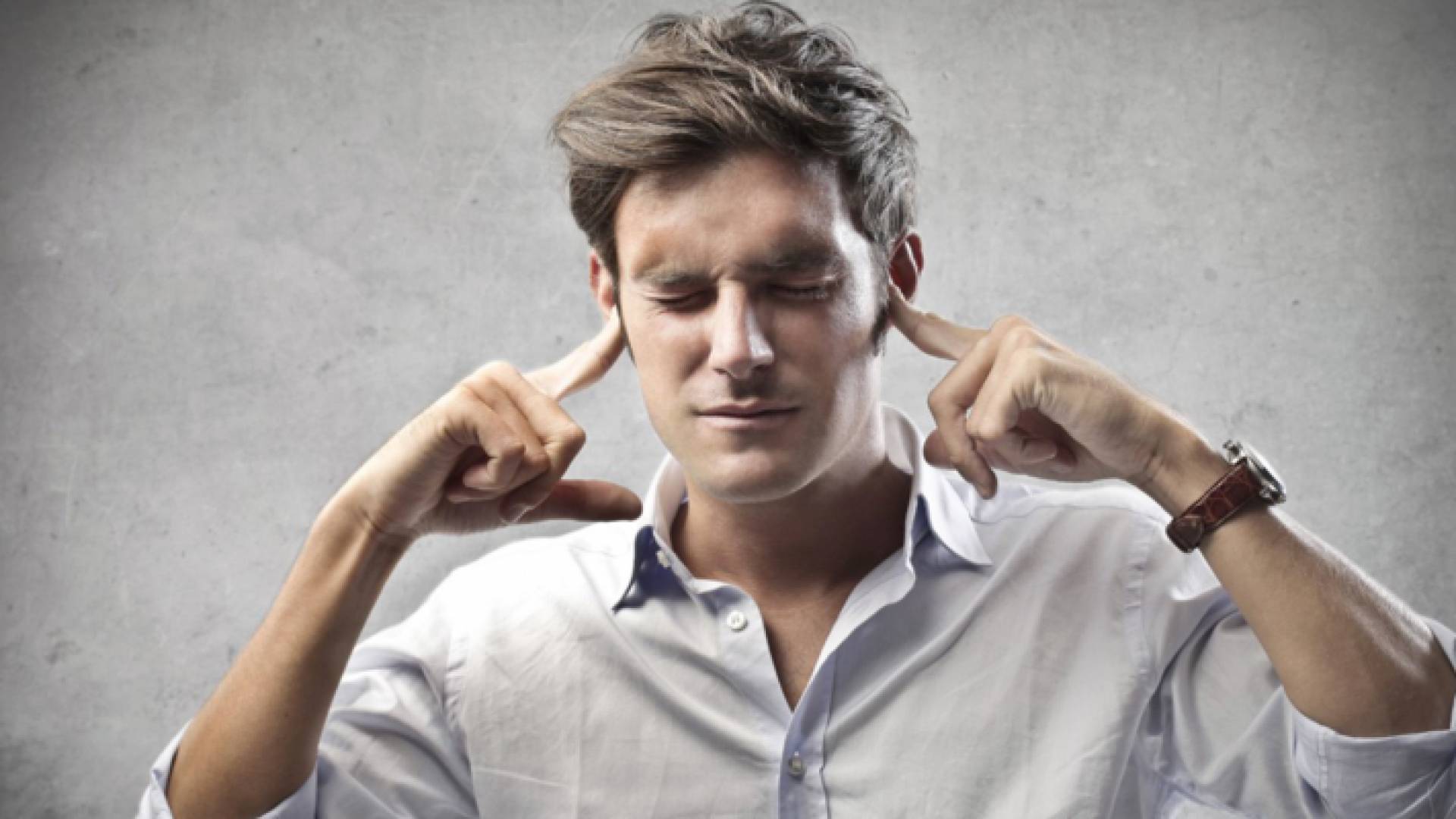 تعبيرية لشخص يضع أصابعه في أذنيه