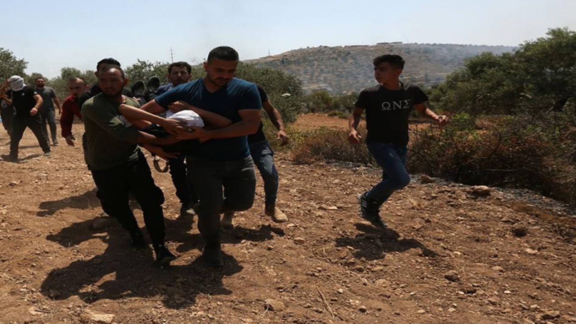 شبان فلسطينيون يسعفون أحد المصابين في مواجهات مع الاحتلال الإسرائيلي