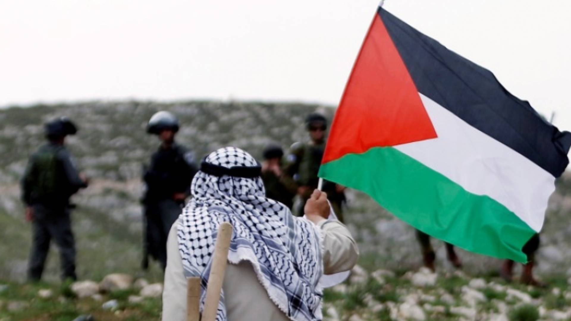 مسن يرفع علم فلسطين امام جنود الاحتلال