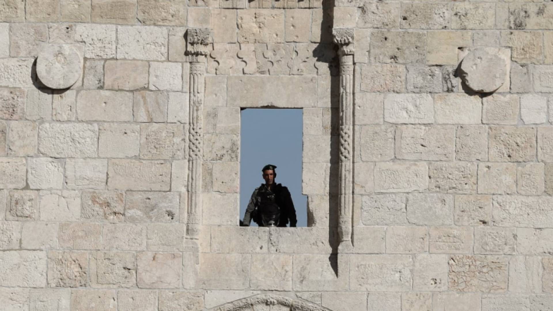 جندي من جنود الاحتلال يعتلي أسوار مدينة القدس