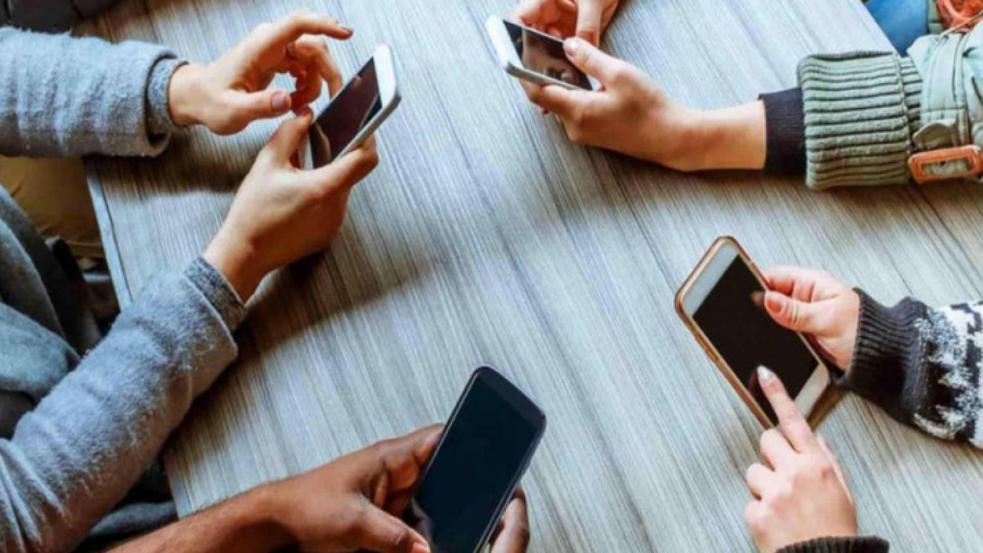 مجموعة من الشباب يستخدمون هواتفهم النقالة