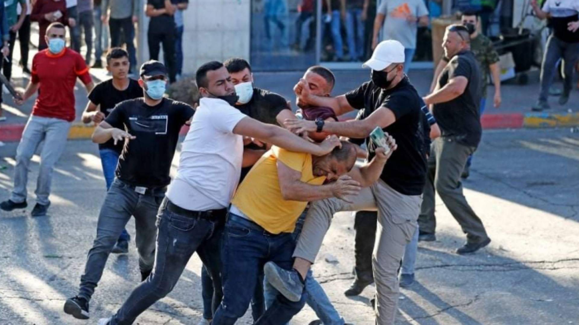 عناصر من الأجهزة الأمنية بلباس مدني قامت بالاعتداء على متظاهرين في رام الله للتنديد بمقتل الناشط نزار بنات