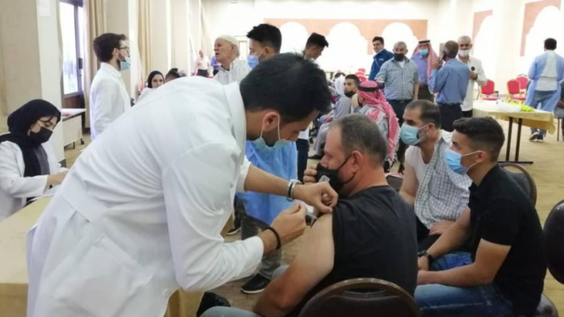 مواطن يتلقى لقاح كورونا في أحد مراكز التطعيم بإربد