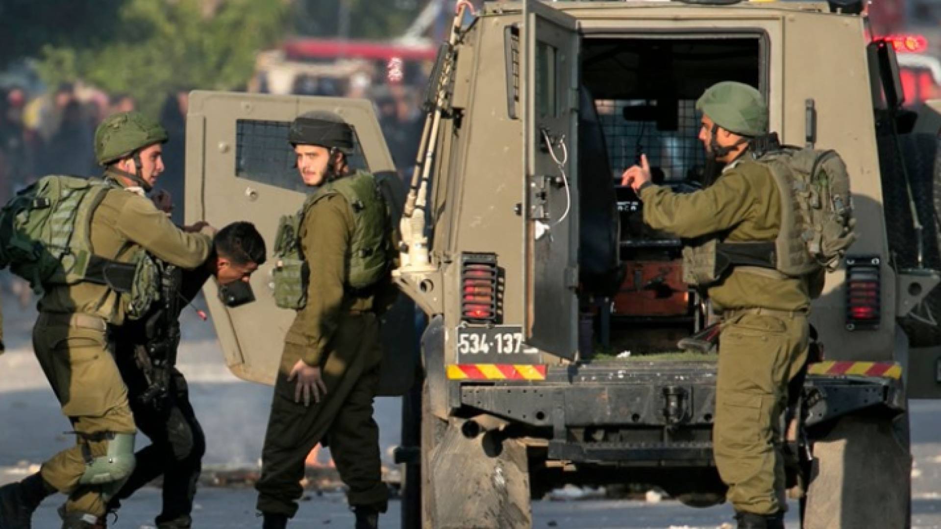 جنود من جيش الاحتلال الإسرائيلي يعتقلون فلسطينيا