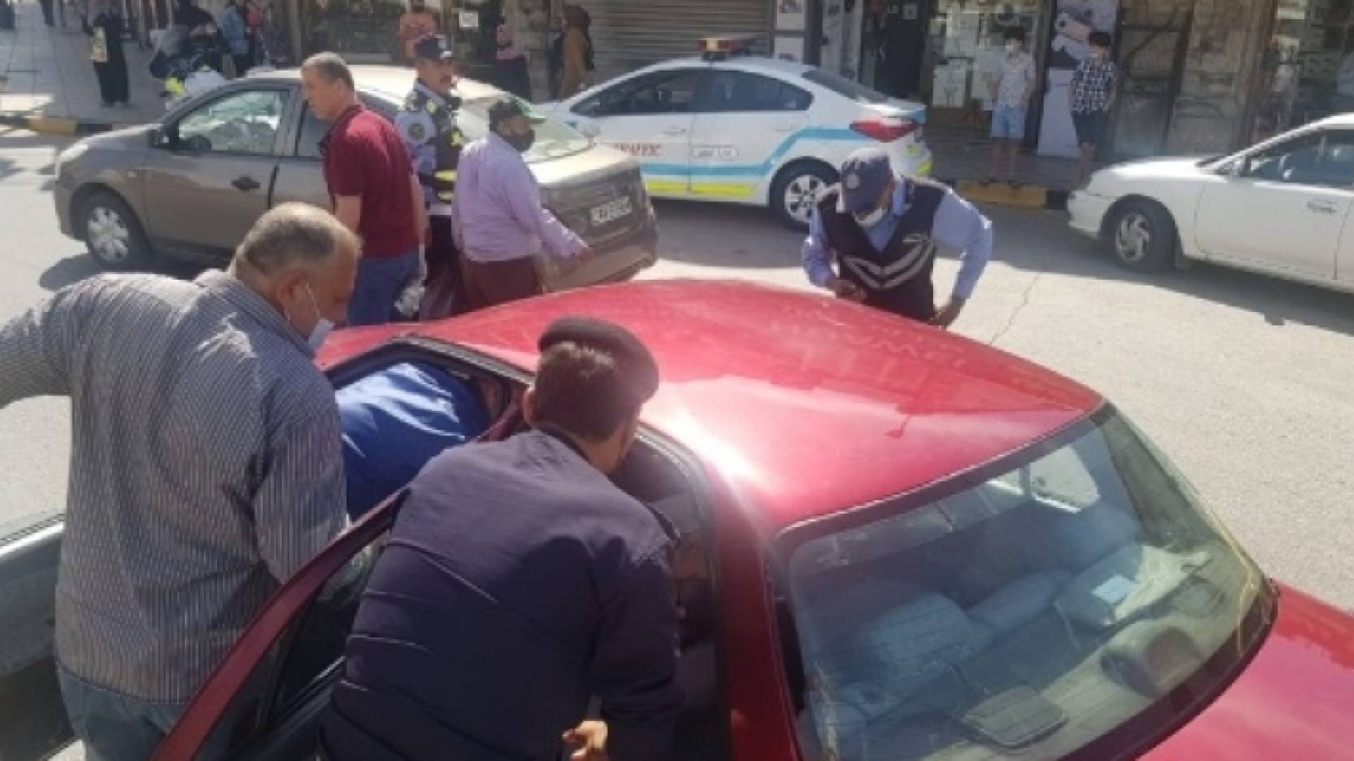 أفراد من الأمن العام الأردني يساعدون أحد الأشخاص بعدما أغمي عليه في محافظة إربد