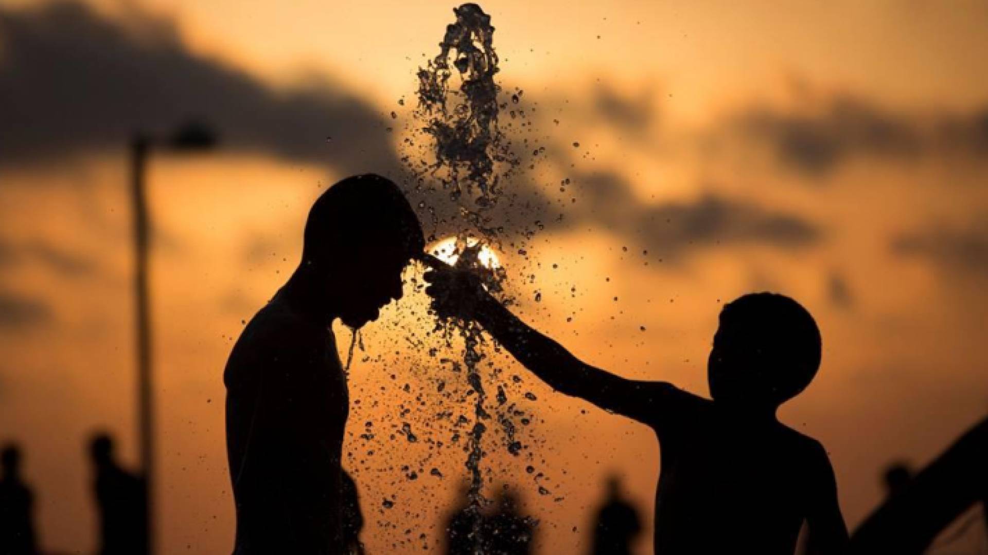 طفلان يلهوان بالماء وسط أجواء حارة