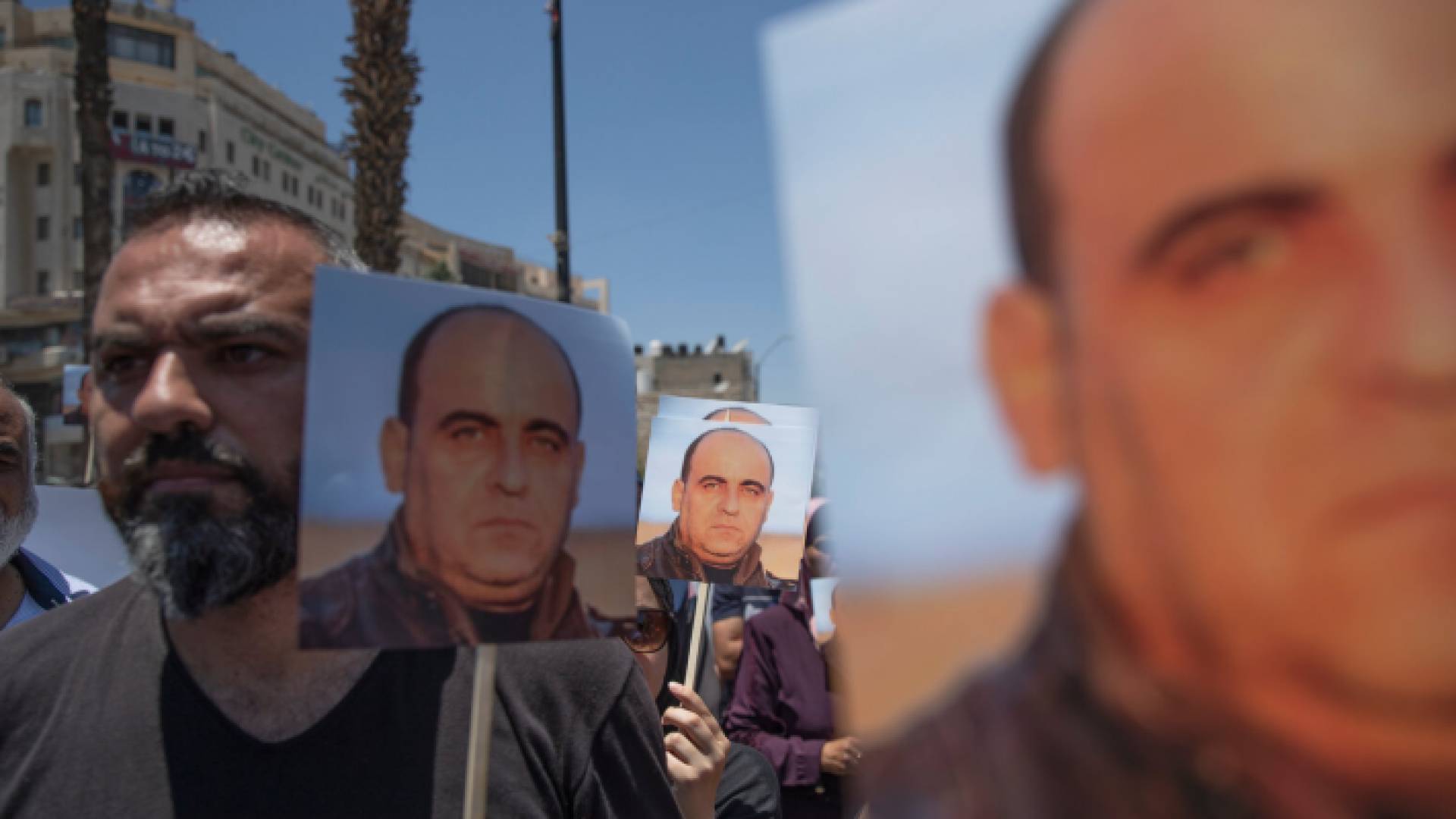 متظاهرون يرفعون صور نزار بنات