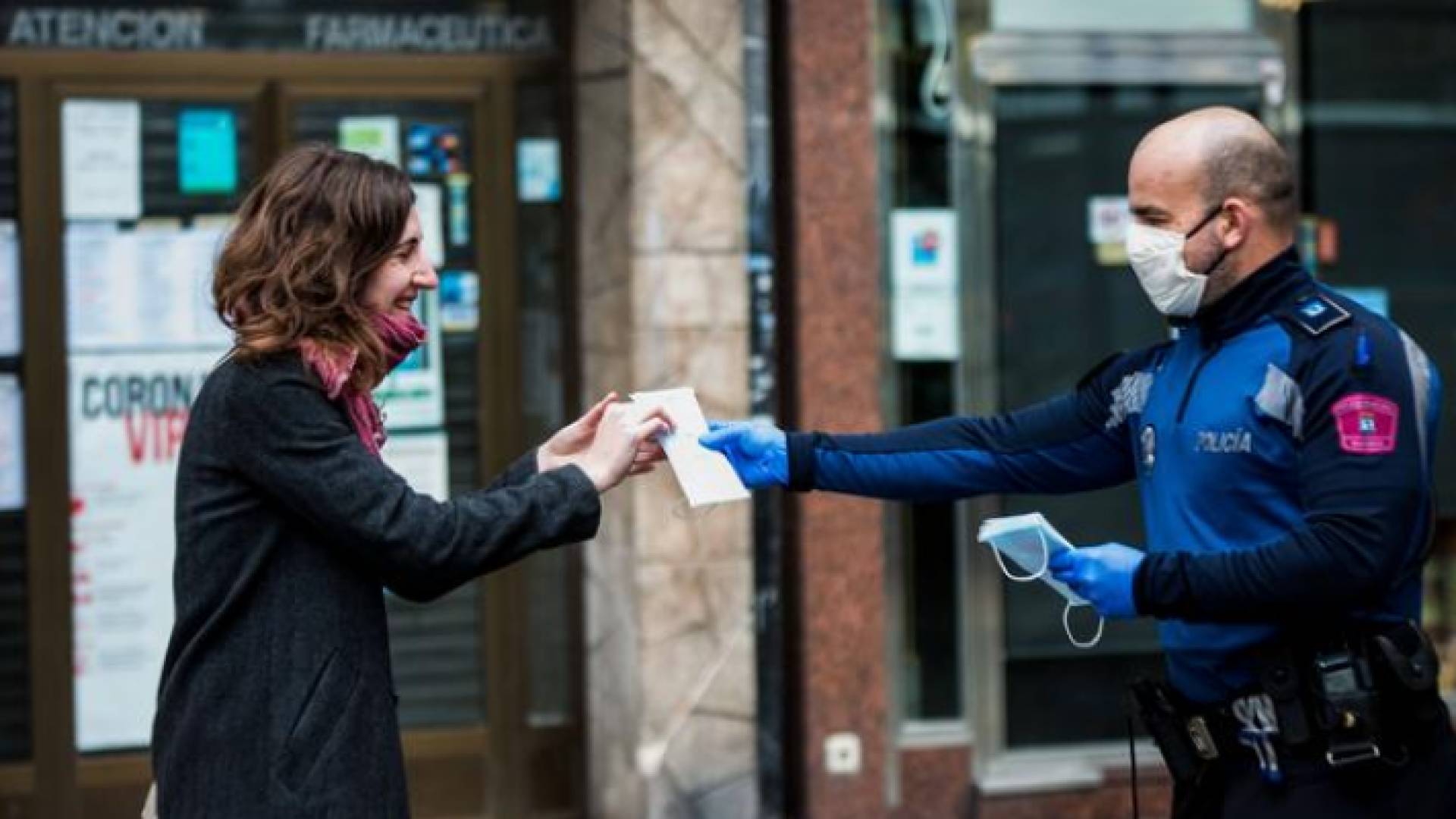 رجل أمن يسلم سيدة كمامة