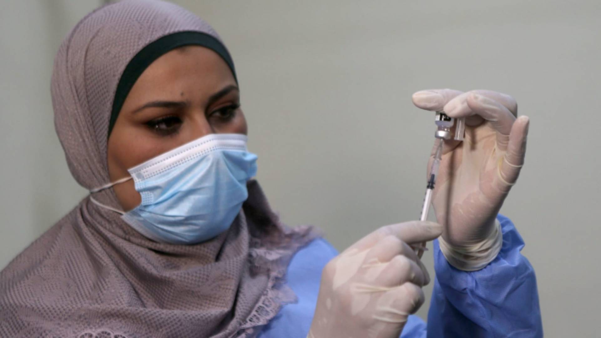 مكعوم كورونا خلال إعطاءه لأحد المتلقين - أرشيفية