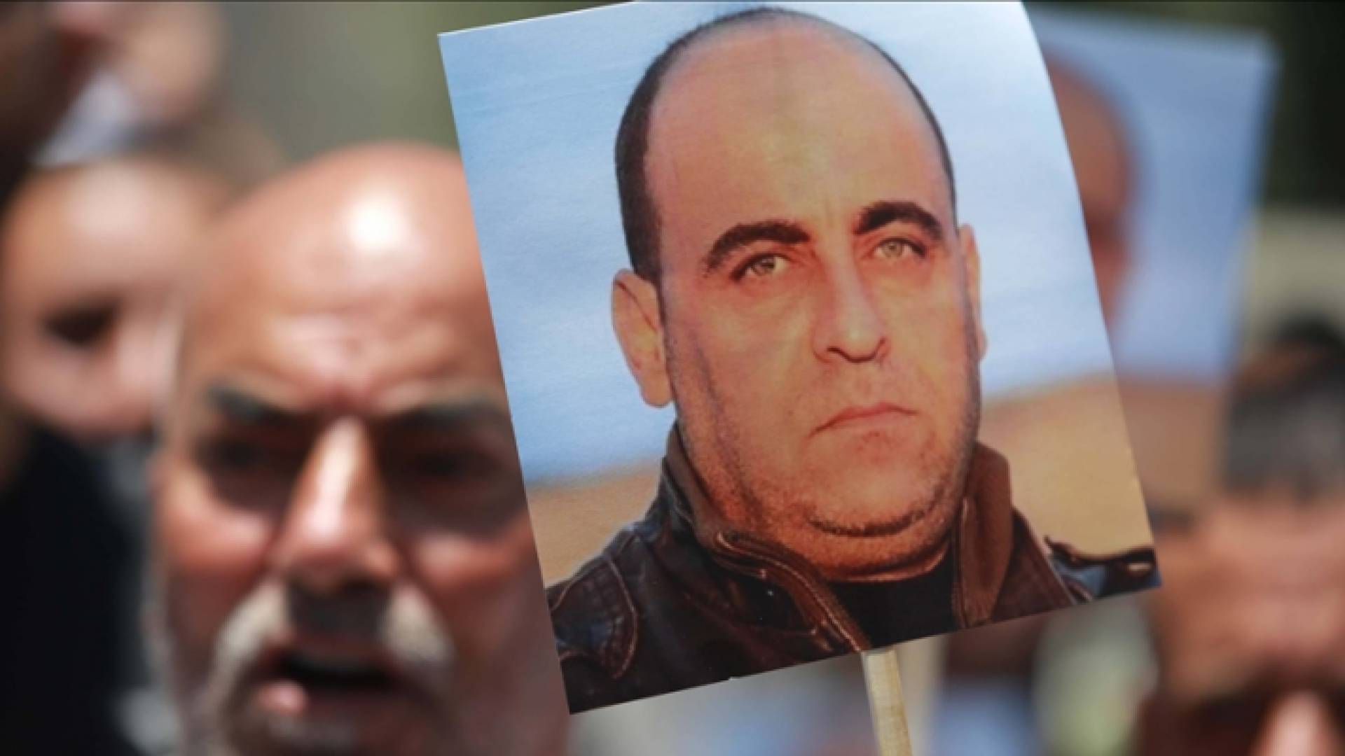 متظاهر يرفع صورة المعارض الفلسطيني نزار بنات