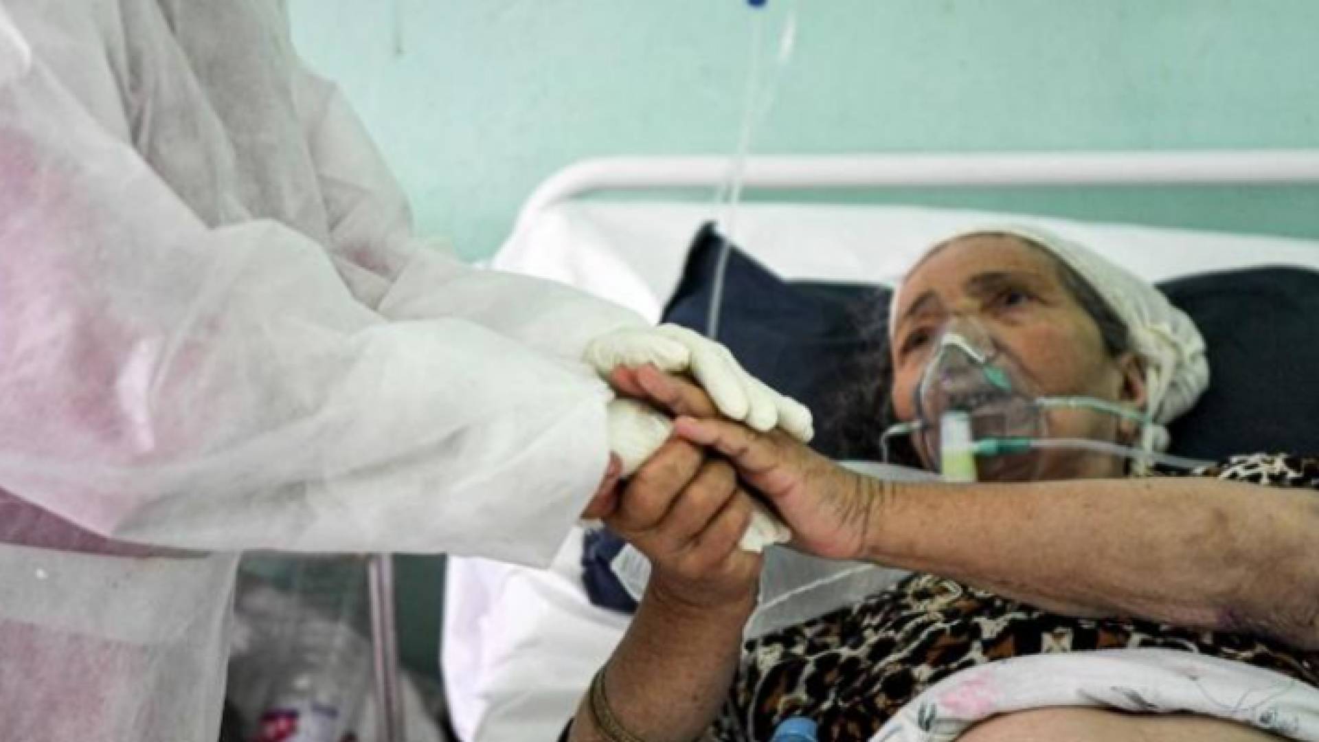 مسنة مصابة بفيروس كورونا تتشبث بيد أحد أفراد الطواقم الطبية في تونس