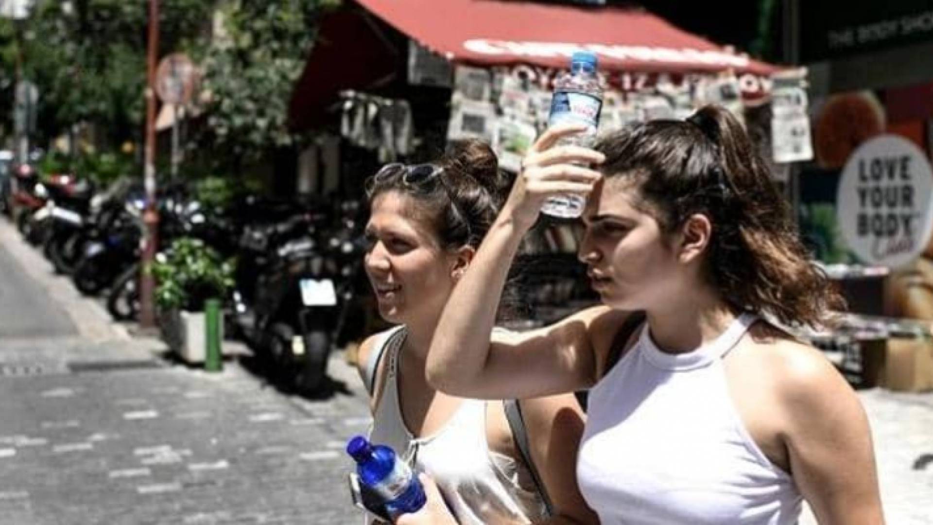 سيدتان تحملان الماء للتخفيف من حرارة الطقس